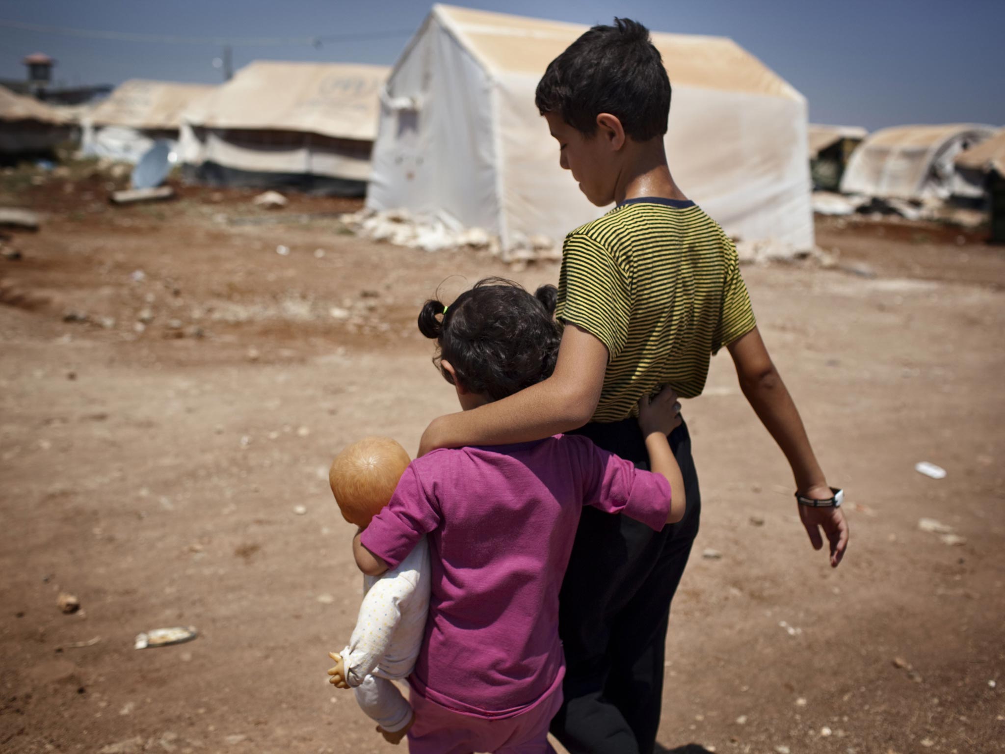 Syrian refugee children walk in the Bab al-Salam refugee camp in Syria's northern city of Azaz