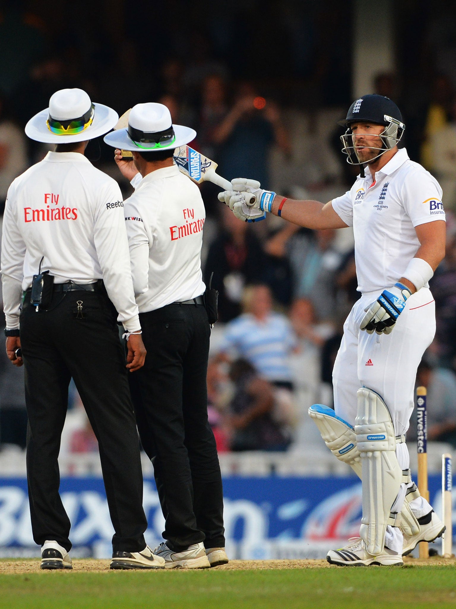 Matt Prior of England talks with umpires Aleem Dar and Kumar Dharmasena as they take a light reading during day five of the 5th Investec Ashes Test match