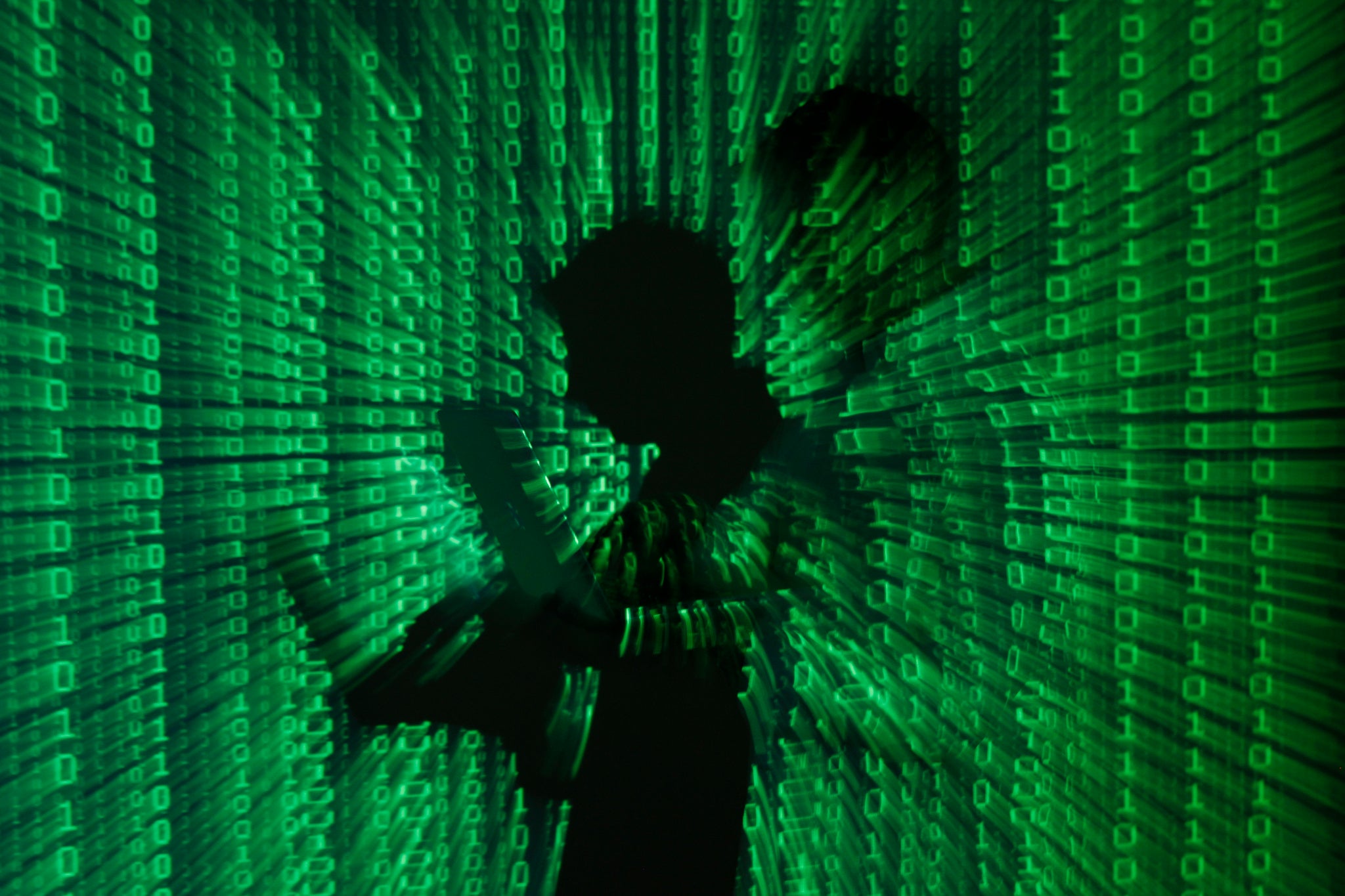 2013An illustration picture shows a projection of binary code on a man holding a laptop computer, in an office in Warsaw June 24, 2013.