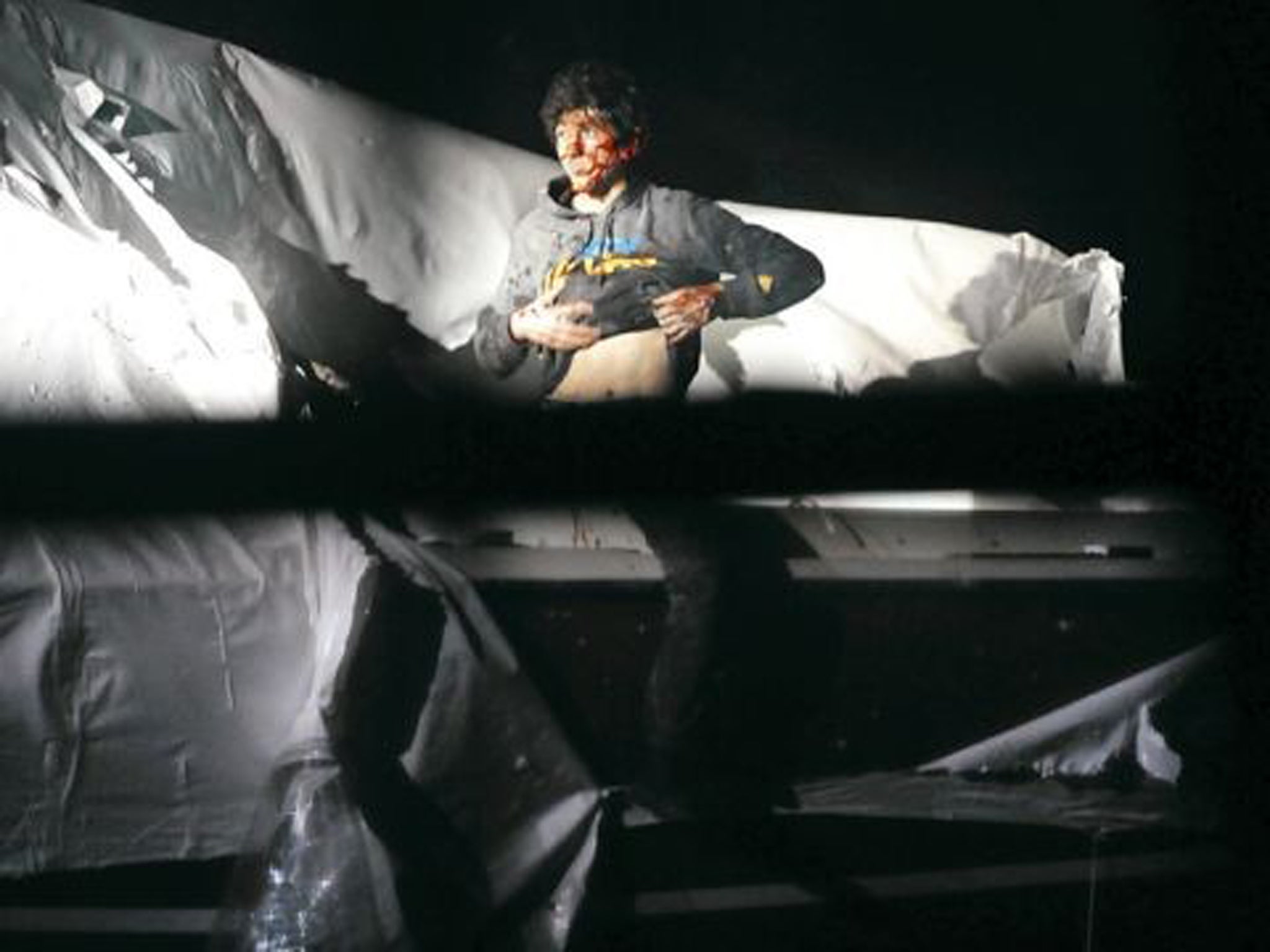 The suspect lifts his shirt, in an attempt to show he is not armed or wearing a bomb