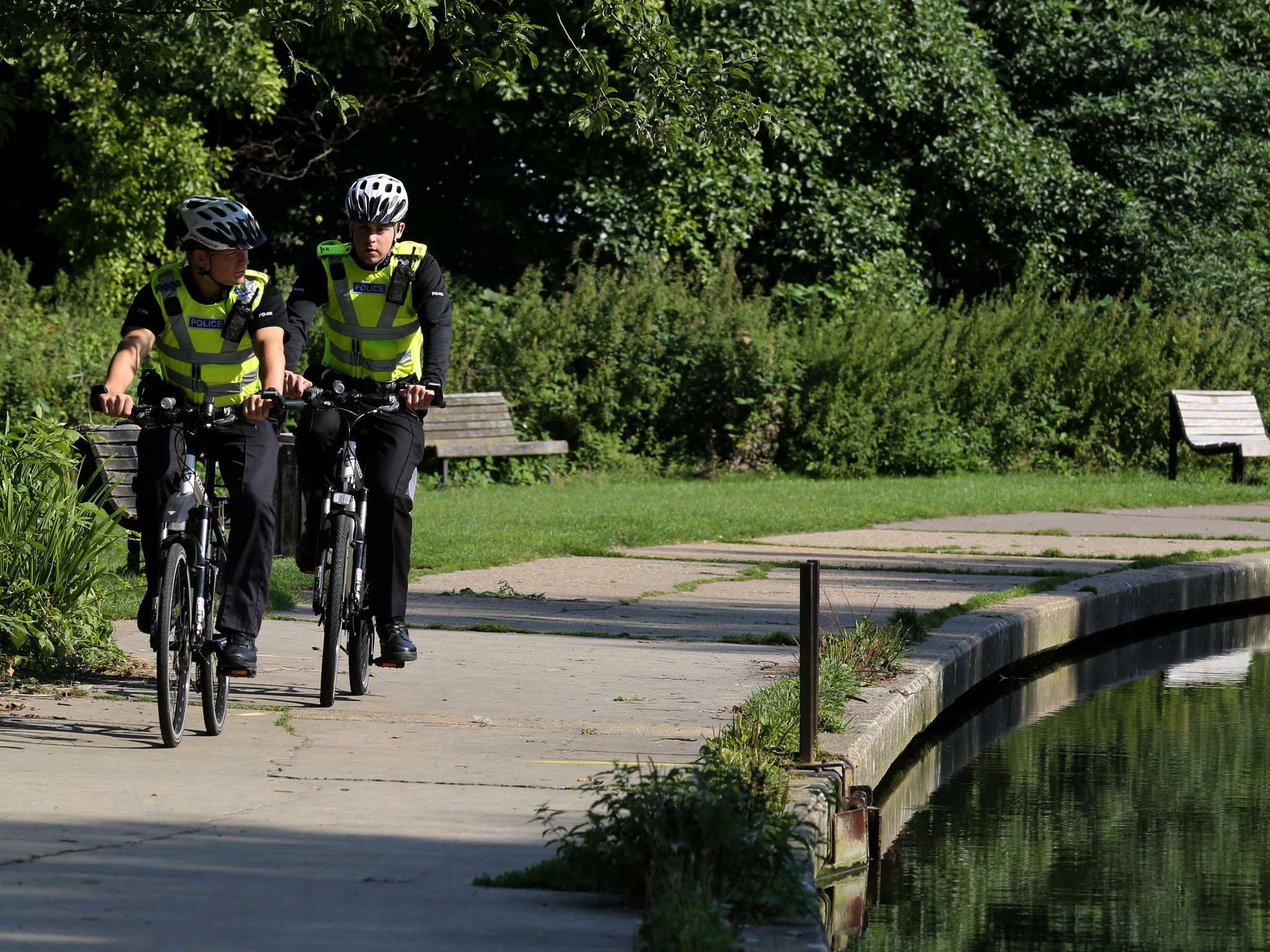 Police officers cycle along the tow path alongside the River Cam in Cambridge where the body of the 12-year-old boy was pulled from the river