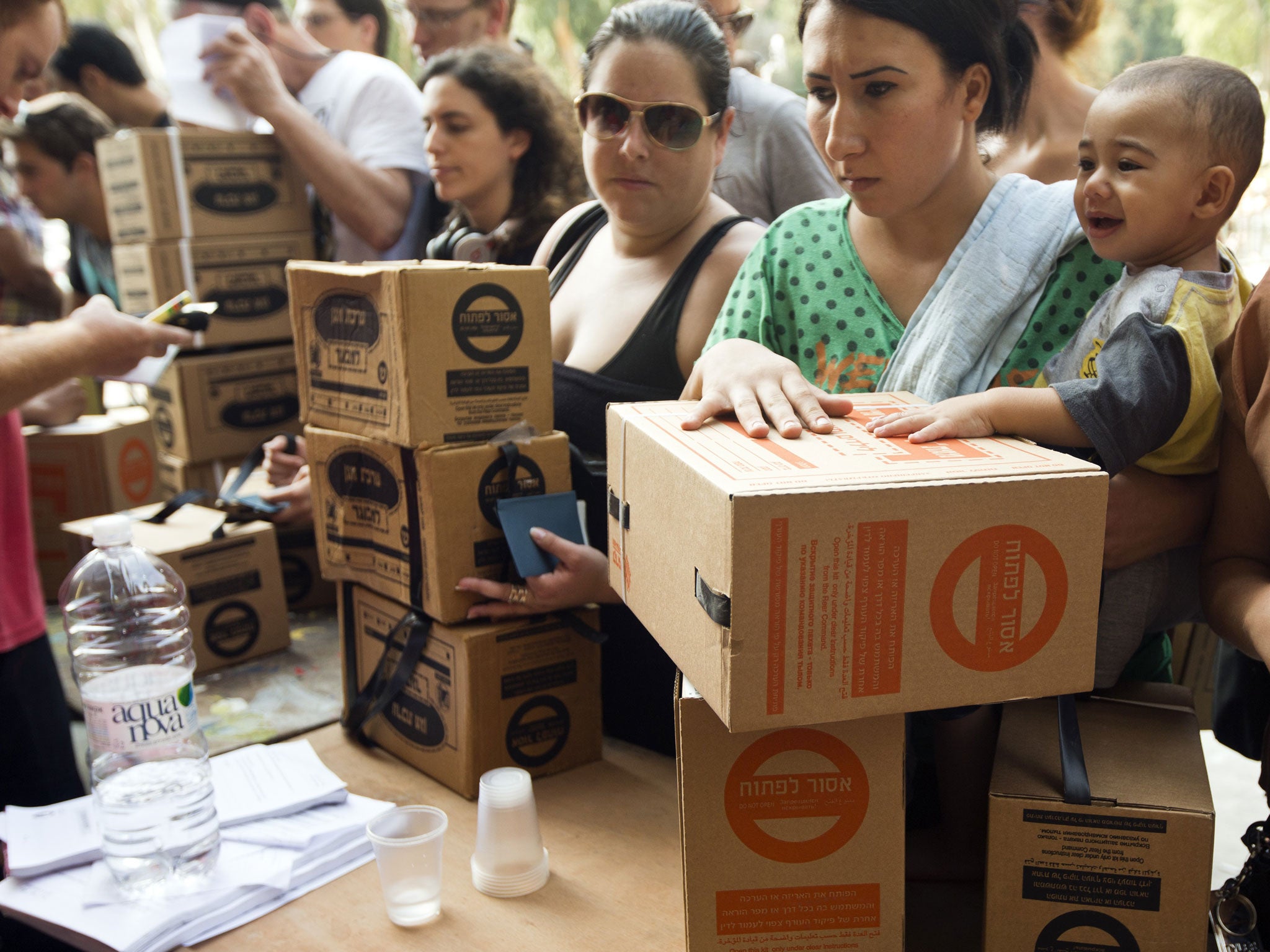 Israelis queue to collect gas mask kits at a distribution center in the Mediterranean coastal city of Haifa, north of Israel, on August 29, 2013.