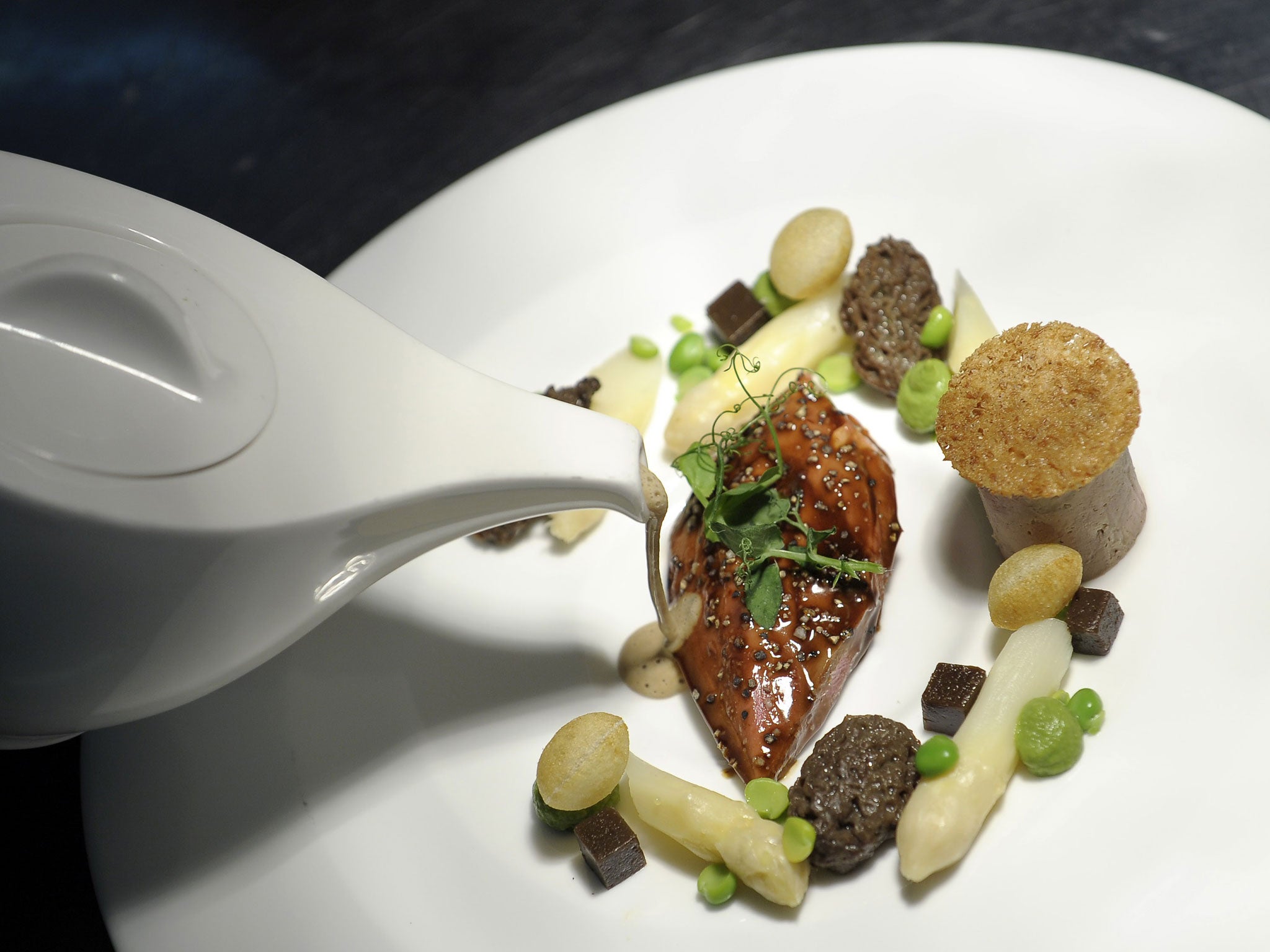 A plate with Dutch asparagus, foie gras, morels and peas.