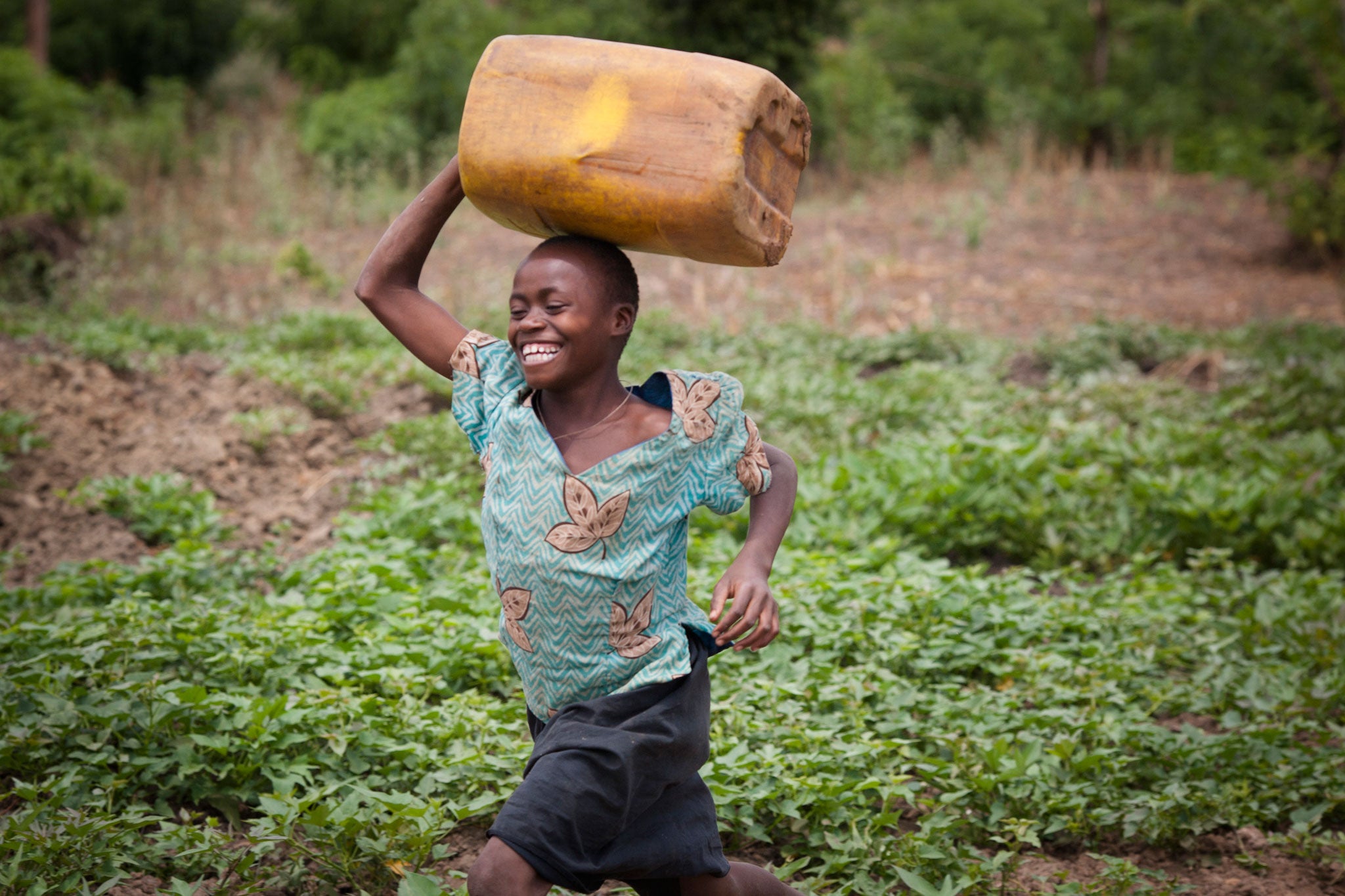 Donatta, 13, runs with an empty jerry can to collect water from a swamp