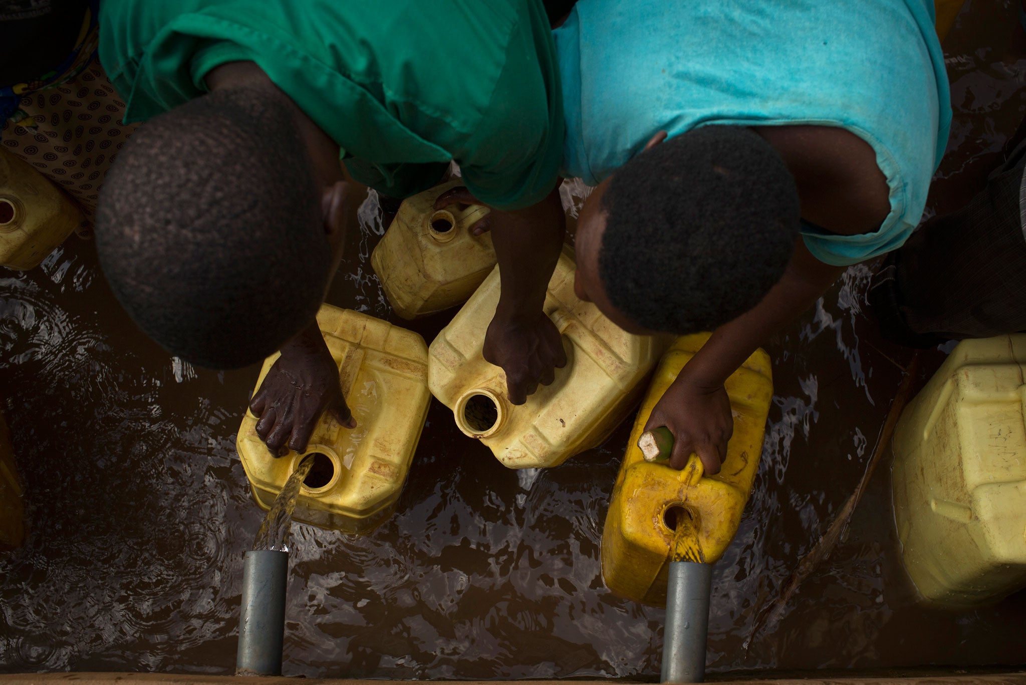 Residents collect clean water from a water point in the village of Rwakibirizi, Rwanda