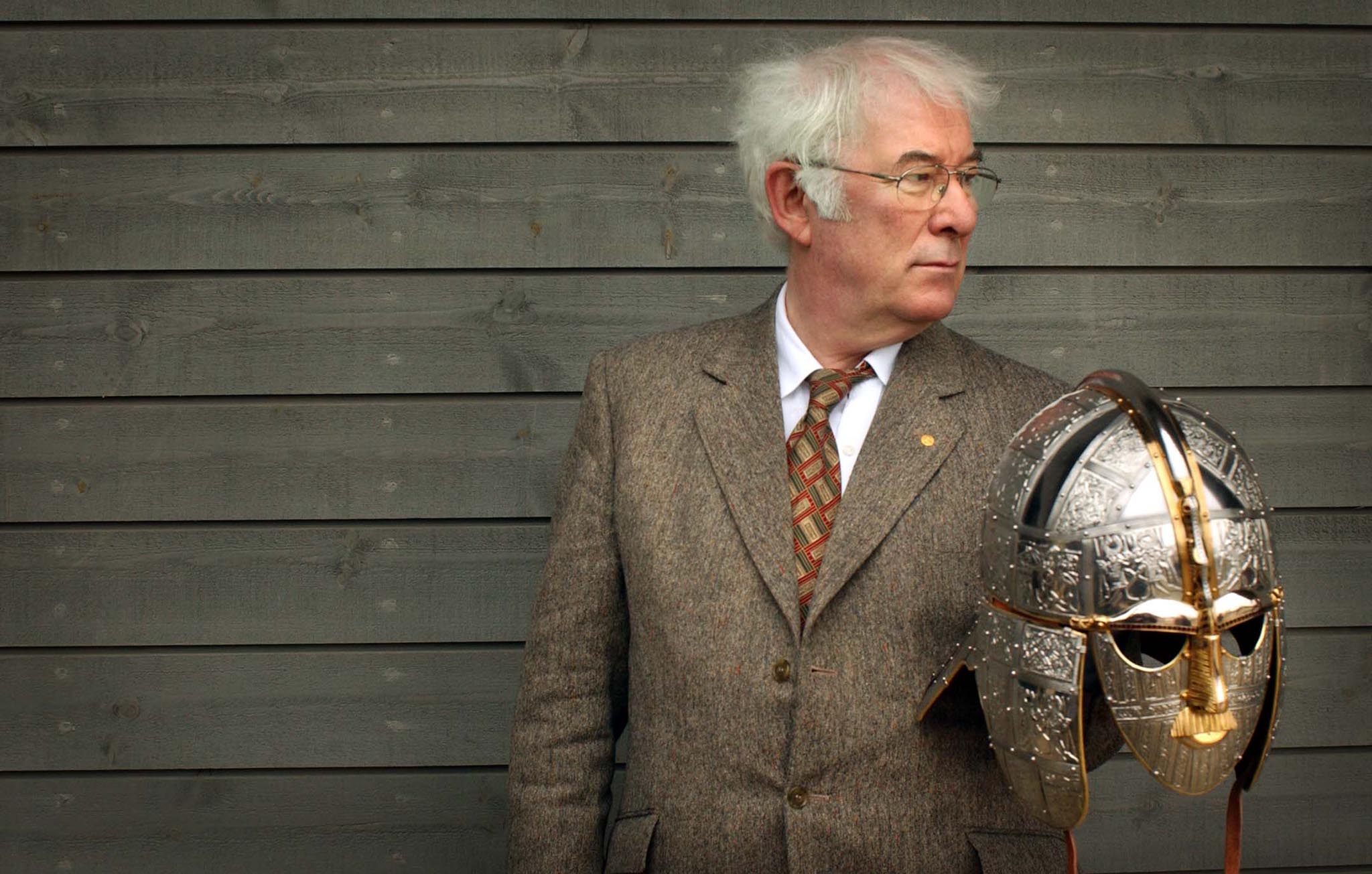 Author of the acclaimed translation of Beowulf, Seamus Heaney holds a replica of the Sutton Hoo helmet