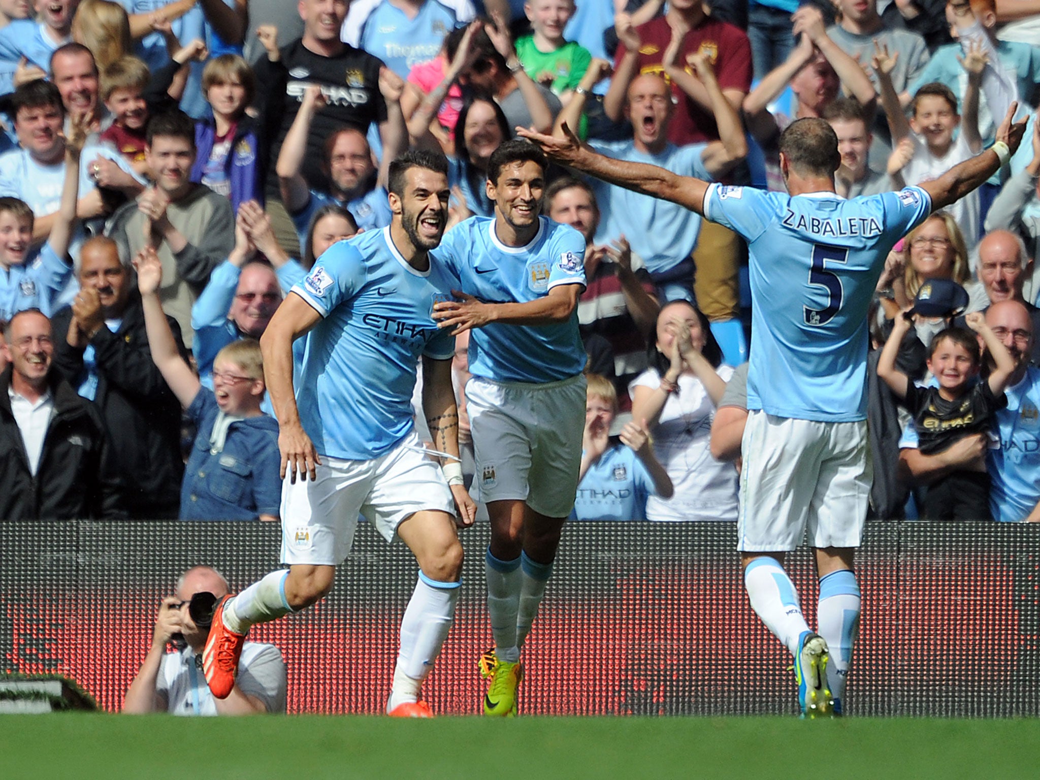 Alvaro Negredo (L) of Manchester City celebrates with team-mates Jesus Navas and Pablo Zabaleta after scoring the opening goal