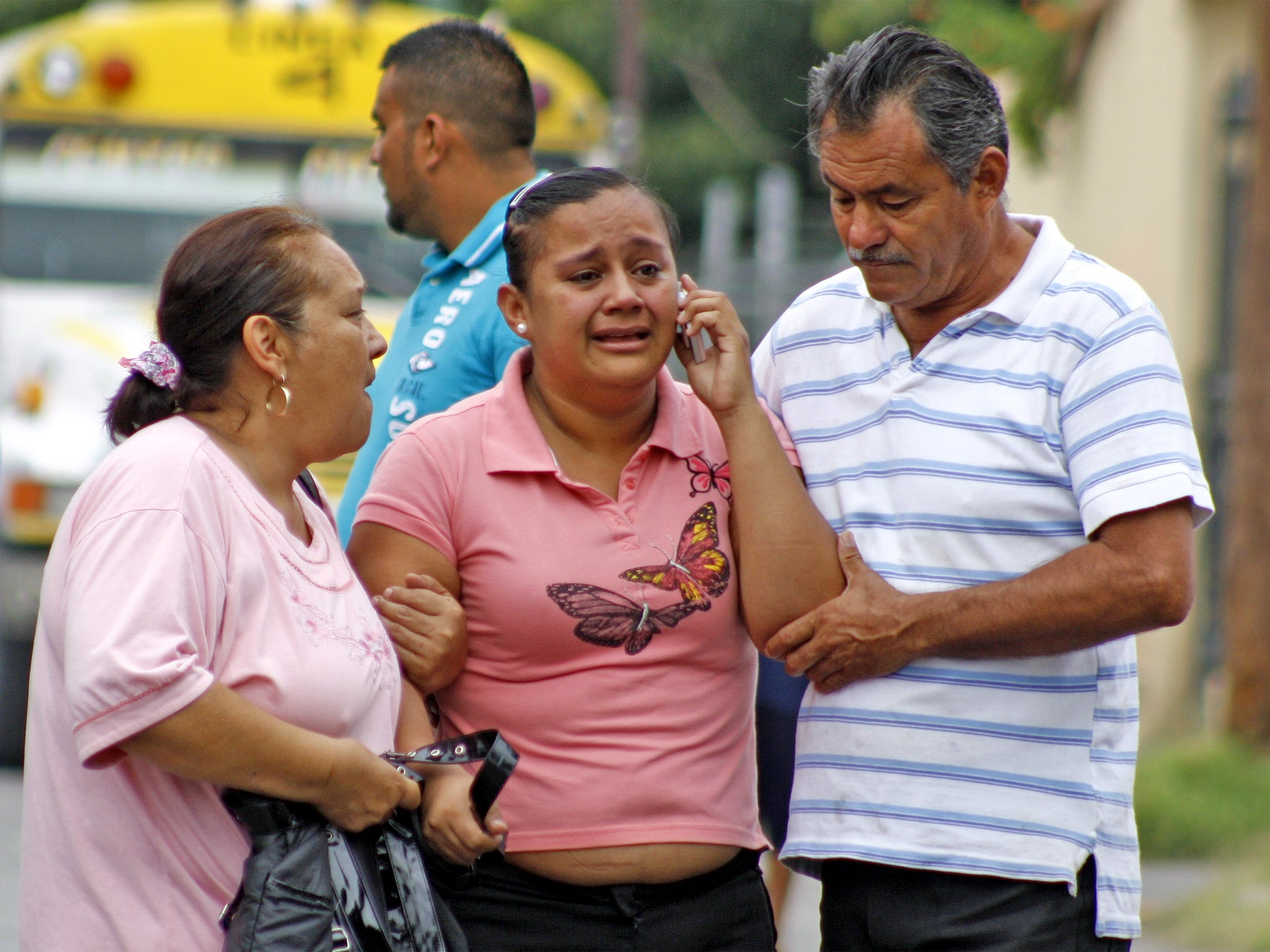 A victim's relative is escorted from the scene