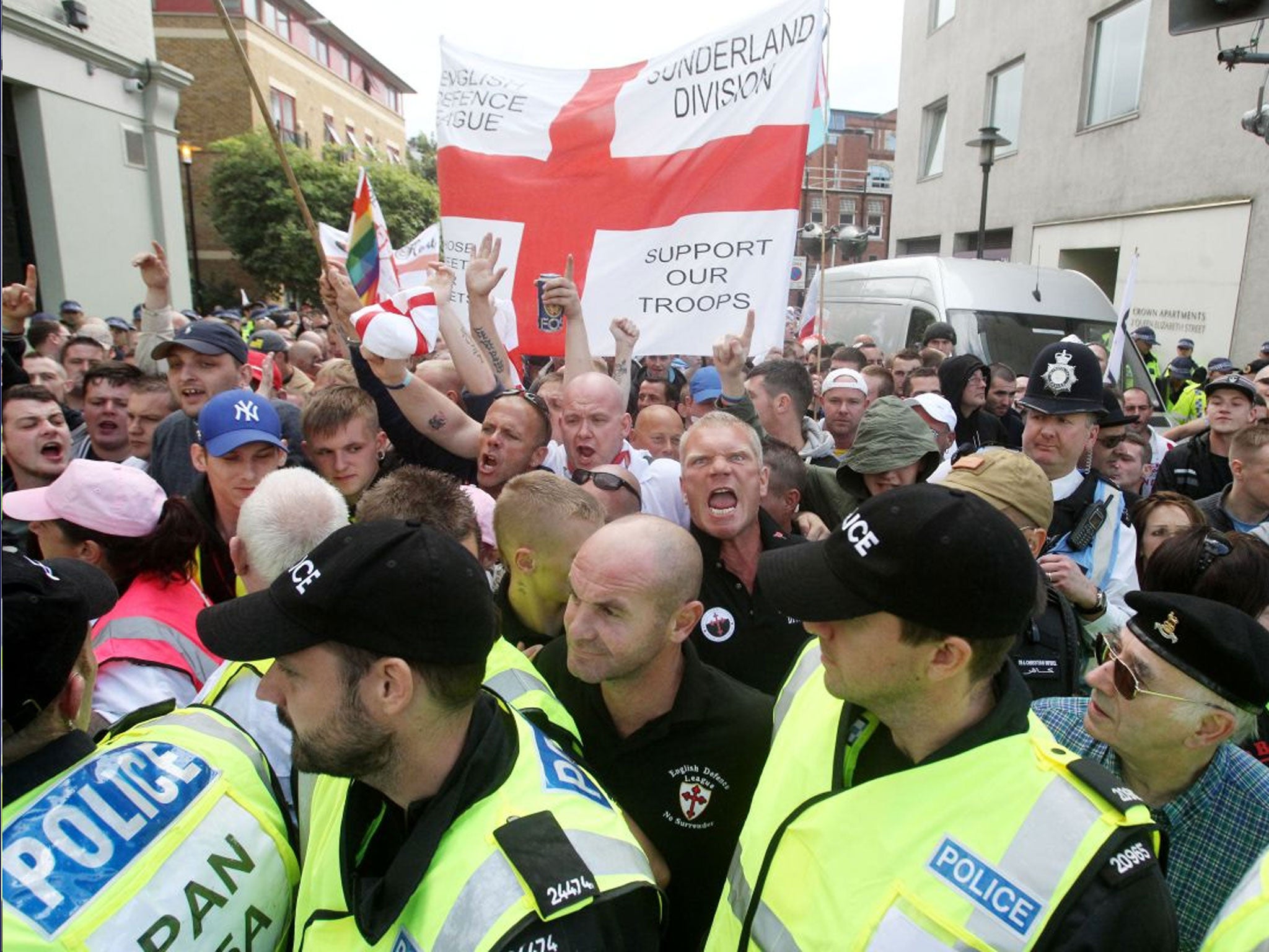 Police escort members of the English Defence League, centre, who marched across Tower Bridge