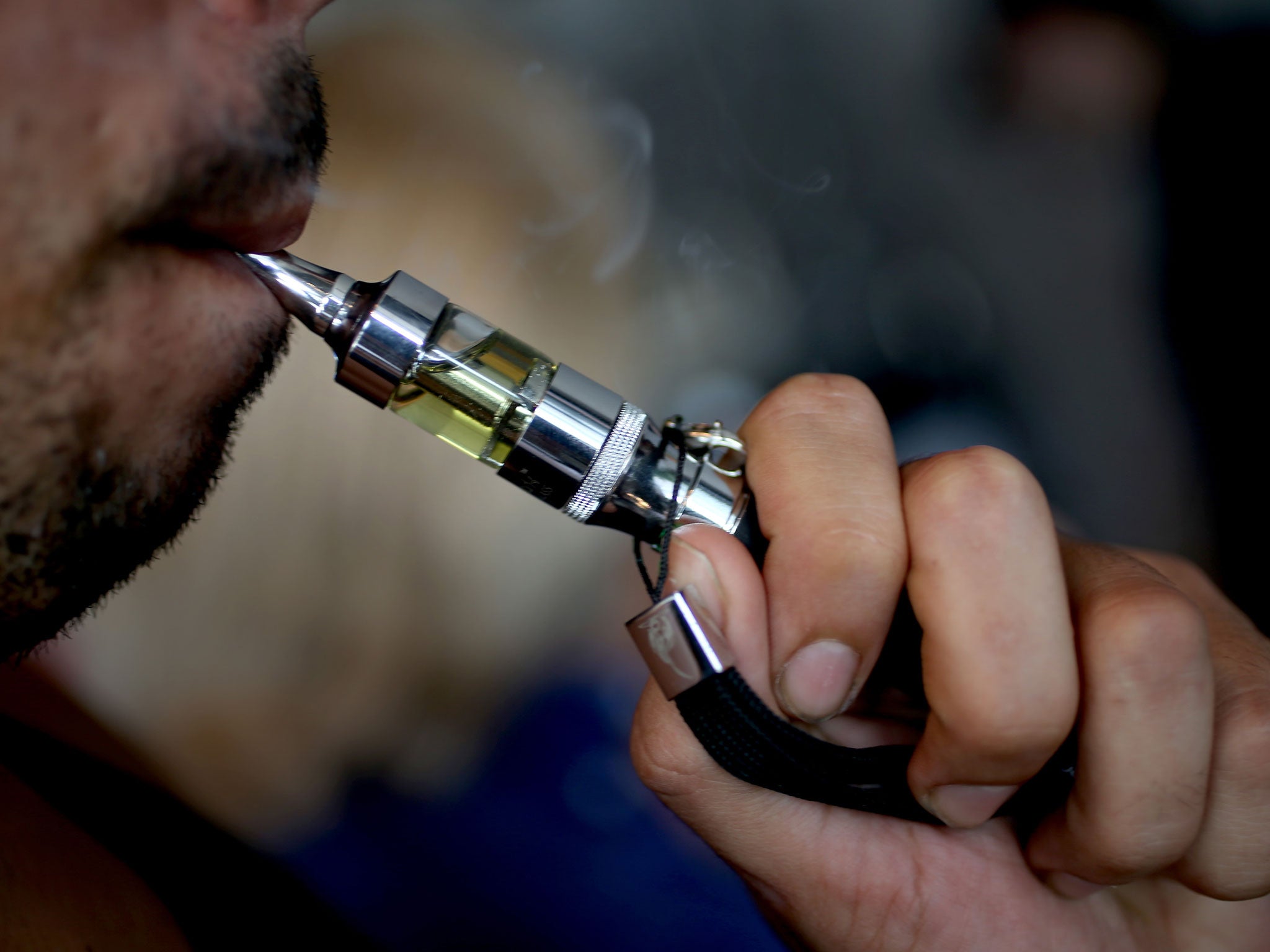 A man tries a flavoured E liquid as he shops for a flavour for his e-cigarette