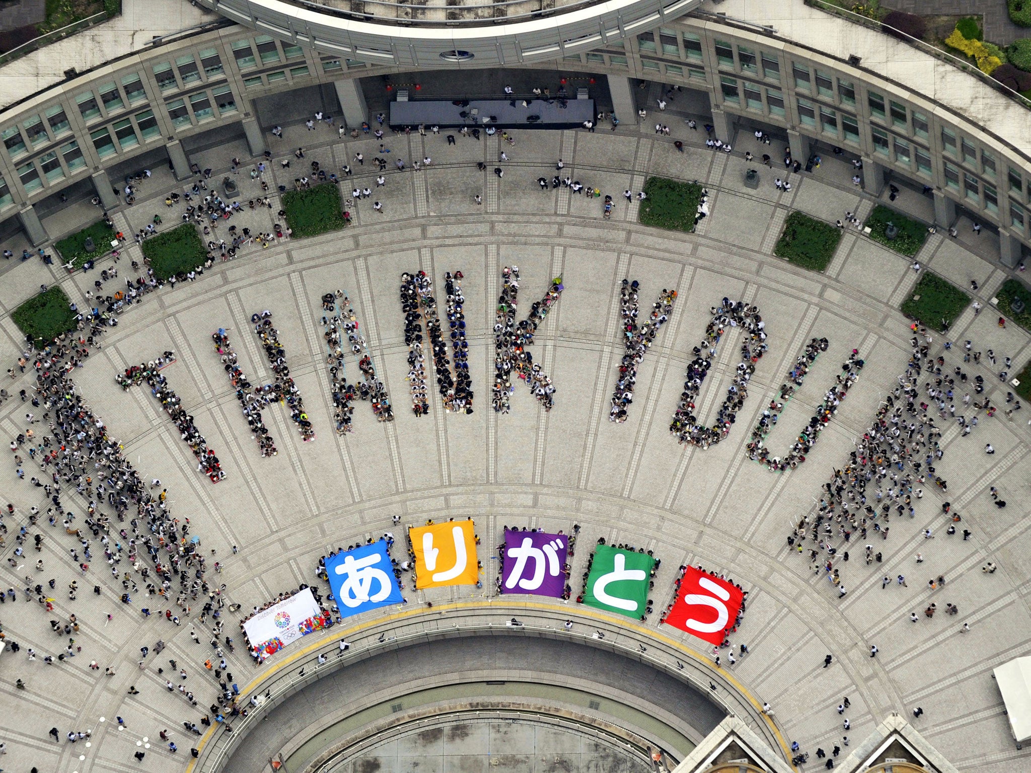 Japanese people form the words ‘Thank You’ in a Tokyo square as part of celebrations