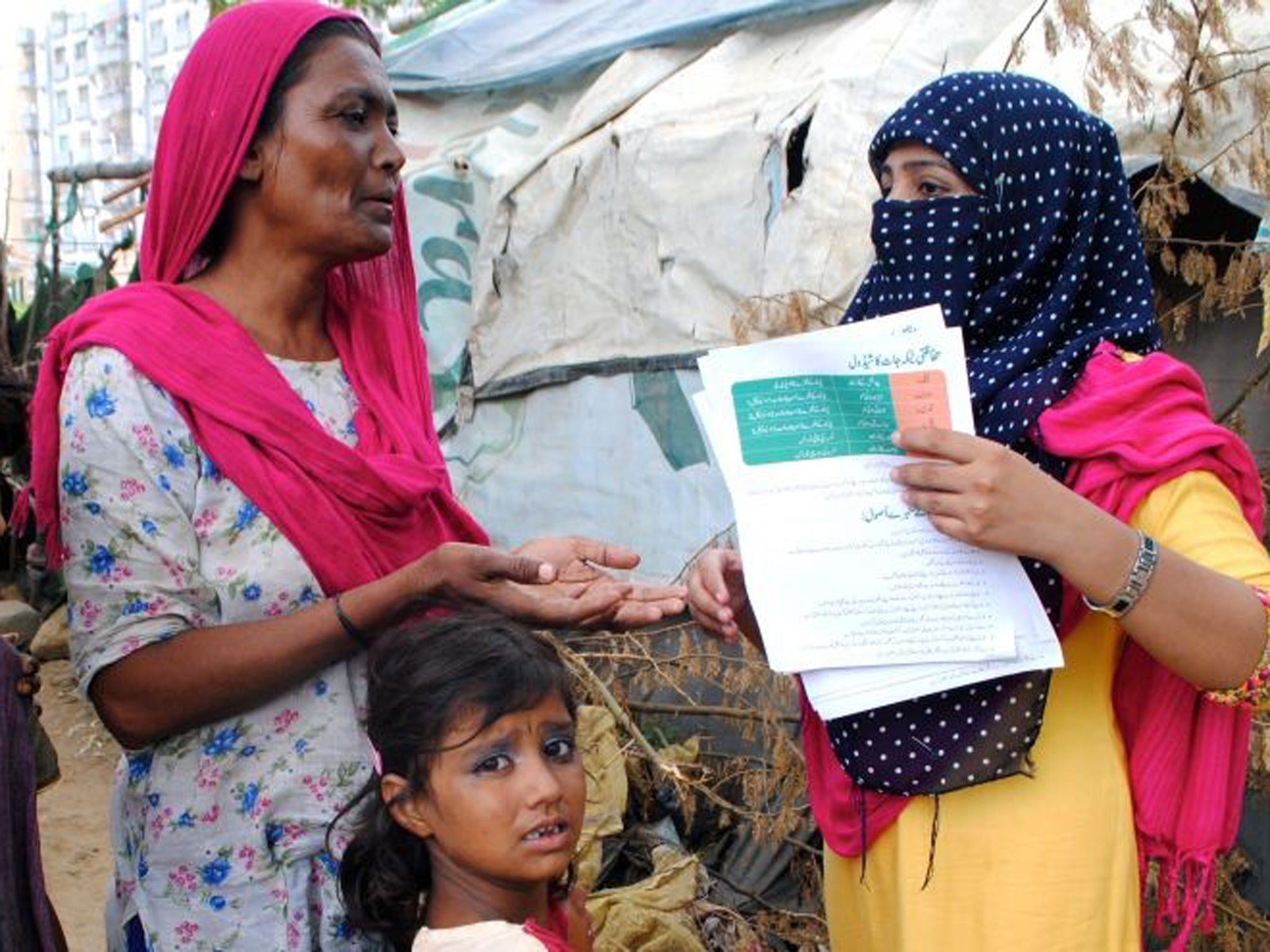 Rabail Mehar, right, speaks with a mother in Karachi during a polio vaccination drive