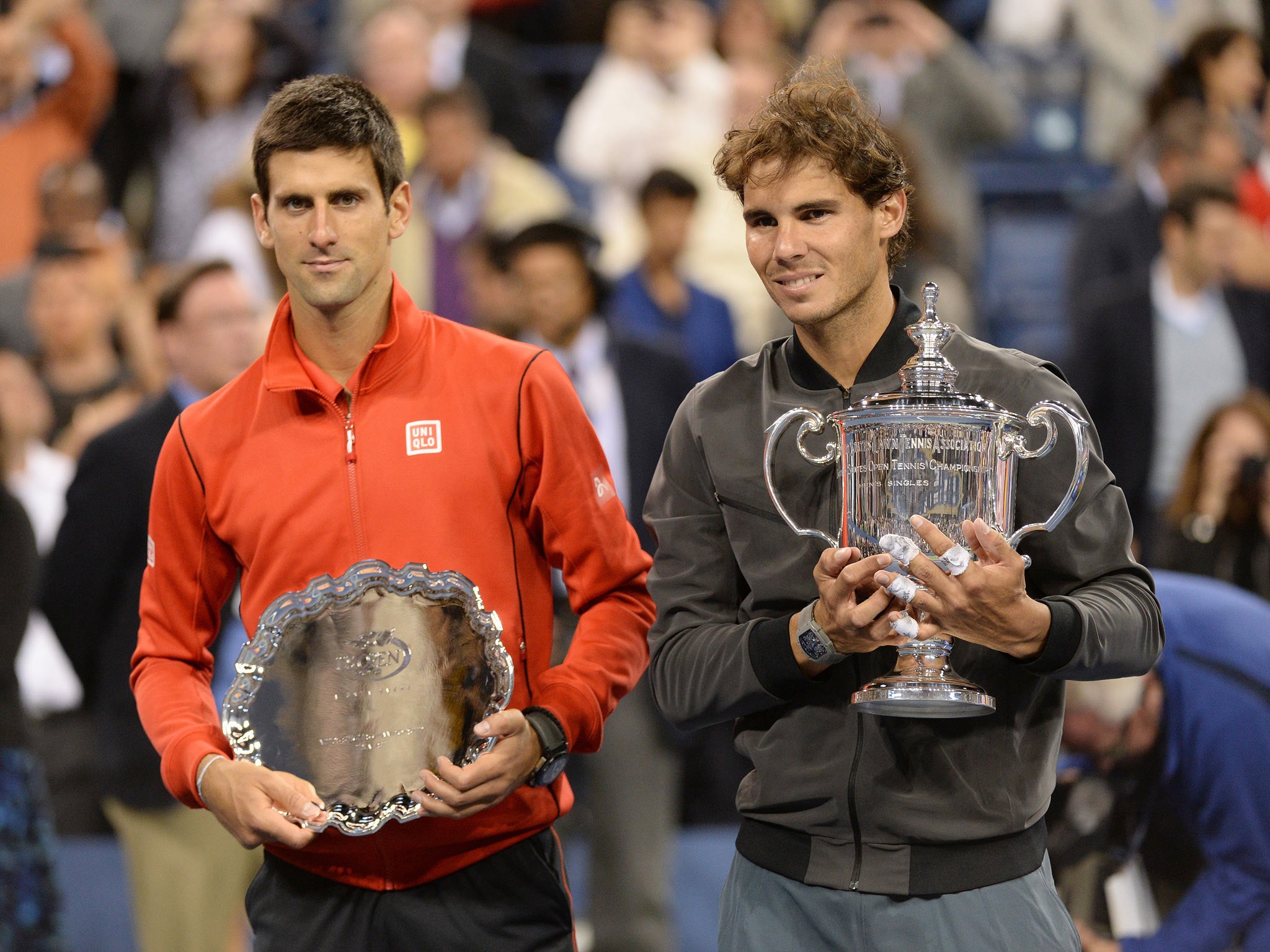 Rafael Nadal of Spain (R) holds the trophy as he celebrates his win over Novak Djokovic of Serbia