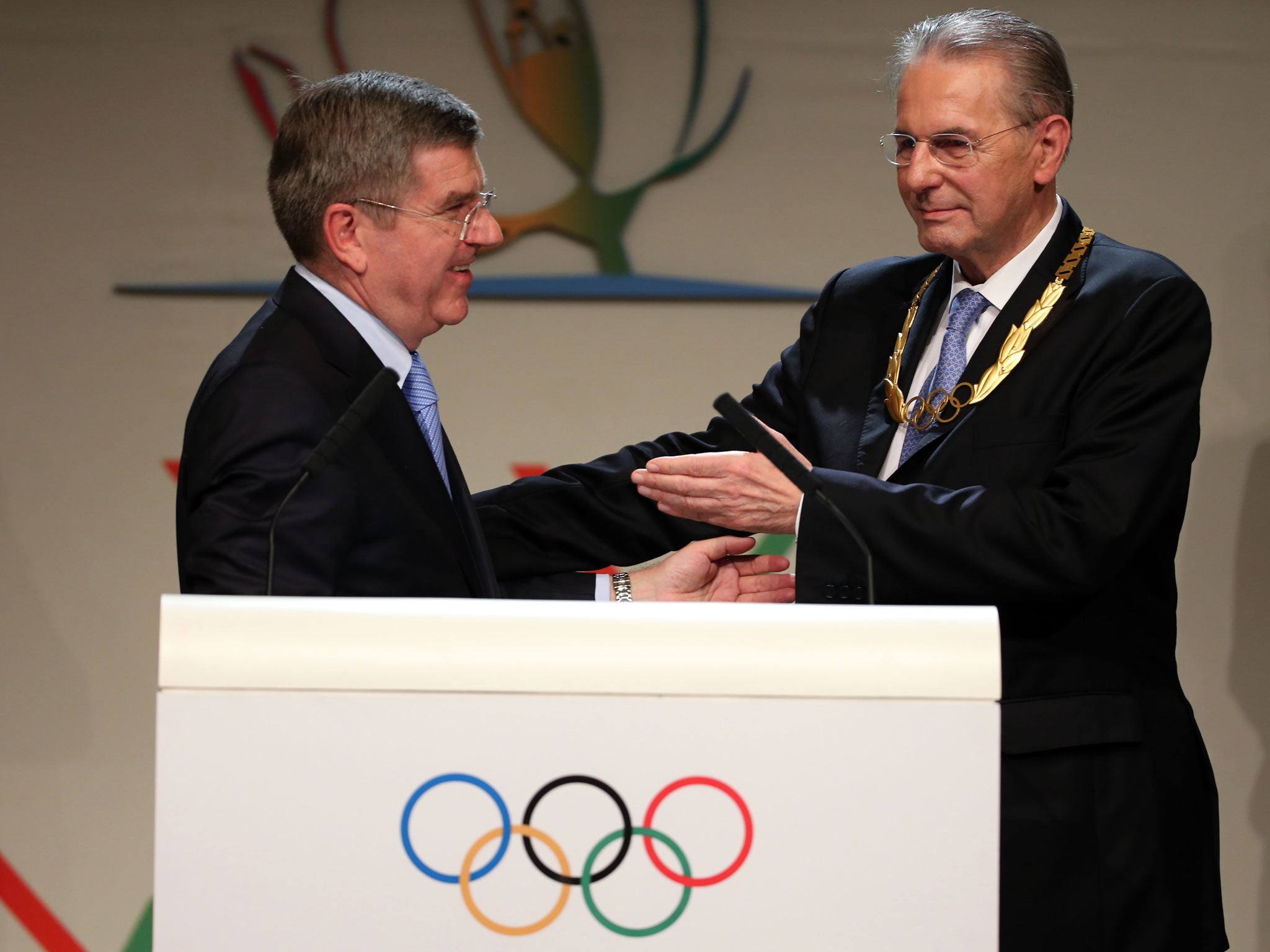 President of the IOC Jacques Rogge receives the Olympic Order from newly announced ninth IOC President Thomas Bach