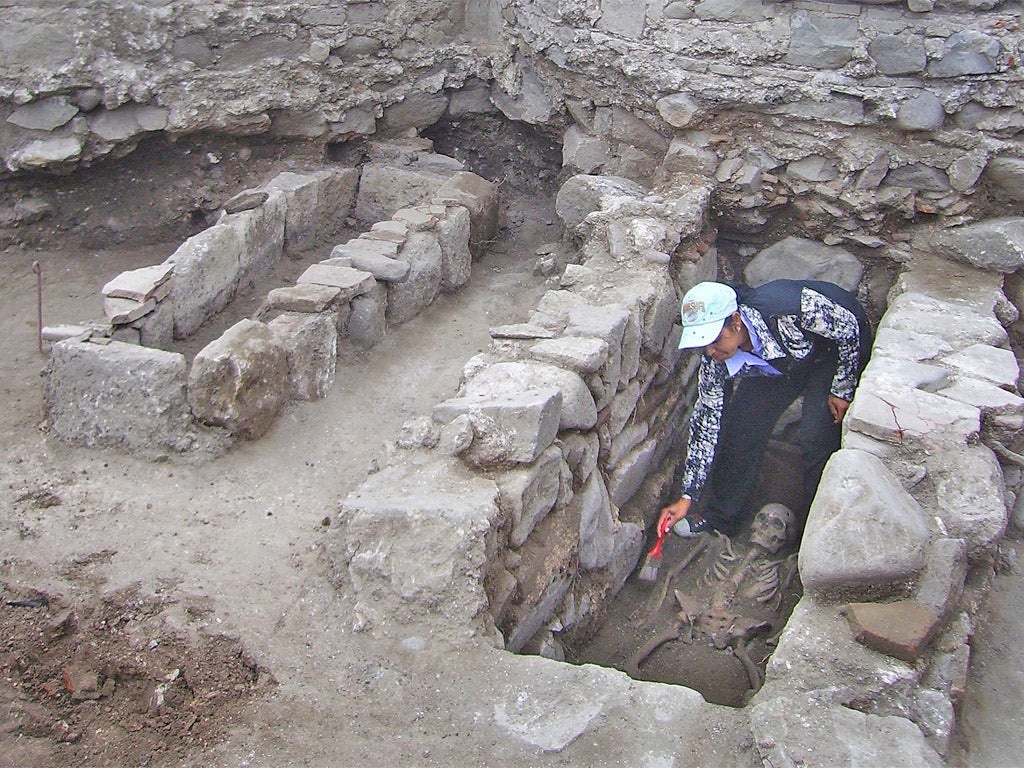 An archaeologist cleaning a skeleton during archaeological excavations in the Black Sea town of Sozopol last year (Getty)