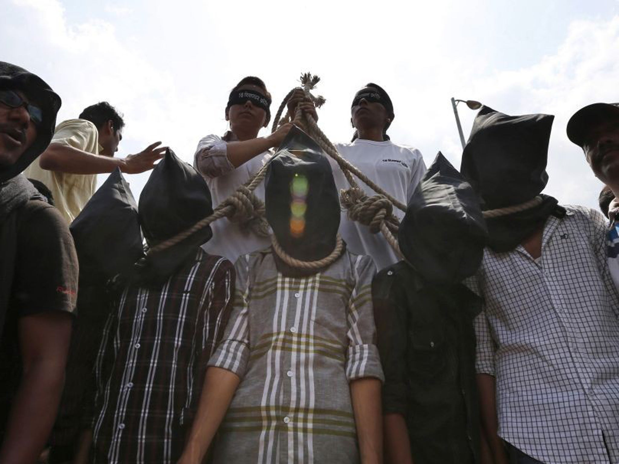 Indian protesters stage a mock hanging scene to demand death sentence for the four men found guilty of the gang-rape in Delhi