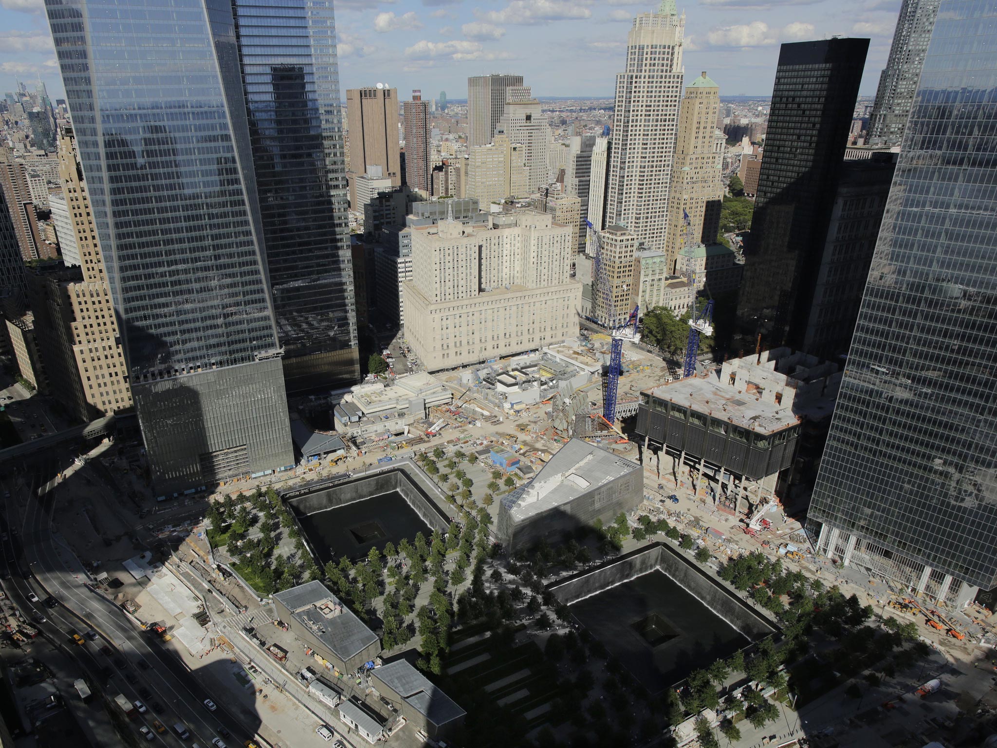 September 2013: The wedge-shaped pavilion entrance of the National September 11 Museum, center, is located between the square outlines of the memorial waterfalls at the World Trade Center in New York