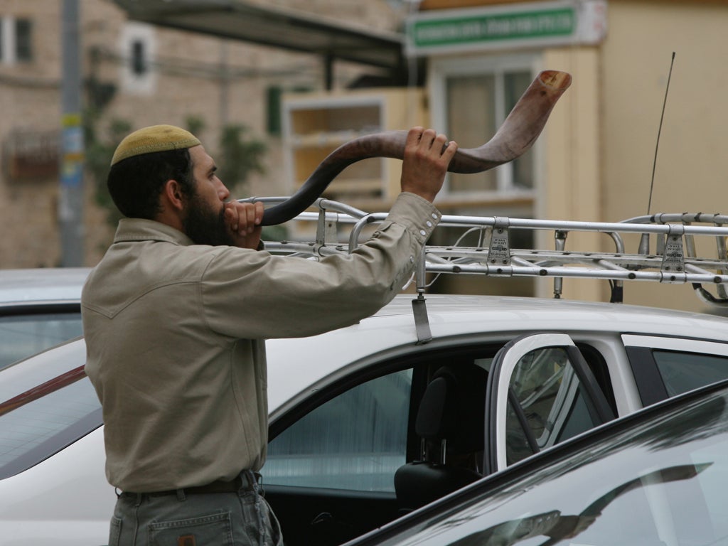 A Jewish settler blows the 'Shofar' horn on the eve of the Day of Atonement, or Yom Kippur