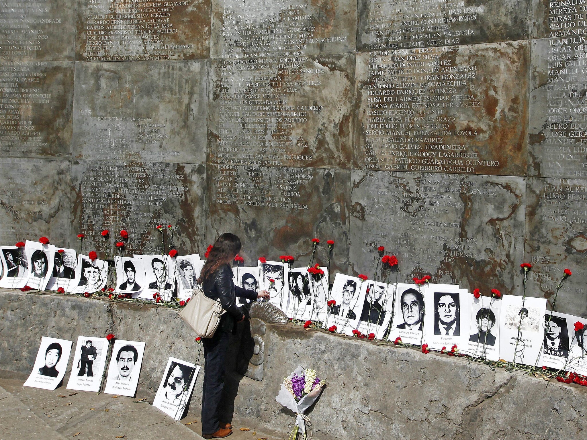 A woman places flowers at a memorial in Santiago for victims of General Augusto Pinochet’s dictatorship. Thousands were tortured to death for opposing military rule after Pinochet’s coup in 1973