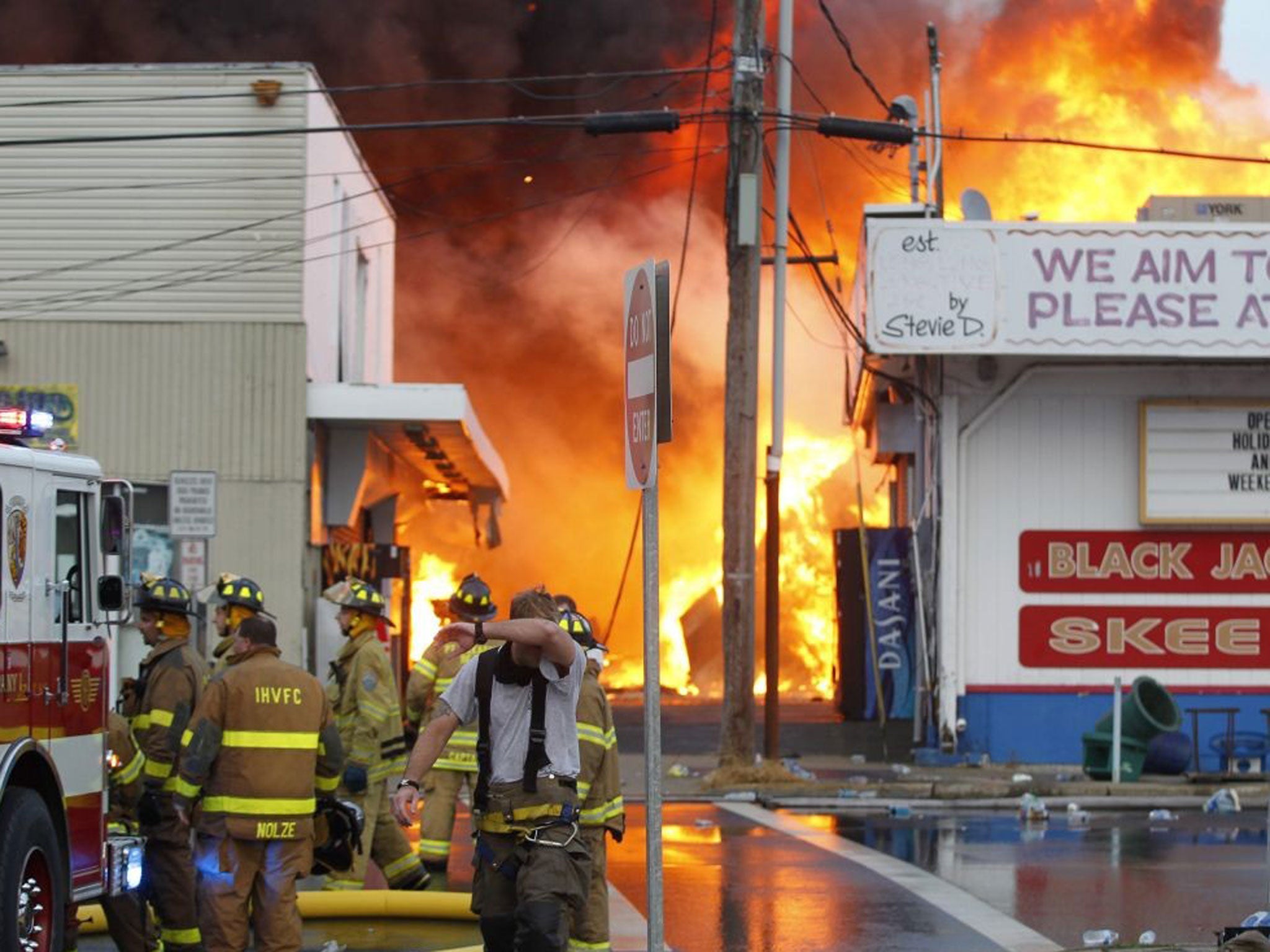 A handout provided by the The Star Ledger shows firefighters pulling back as they battle a six-alarm fire fueled by strong winds consumes the south end of the Seaside Park, New Jersey Boardwalk in Seaside Park, New Jersey