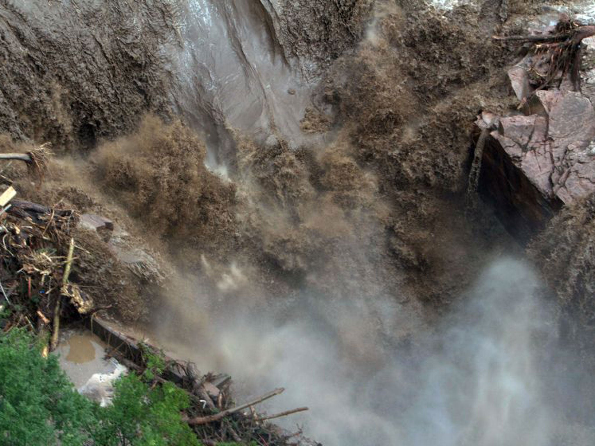 a raging waterfall destroying a bridge along Highway 34 toward Estes Park