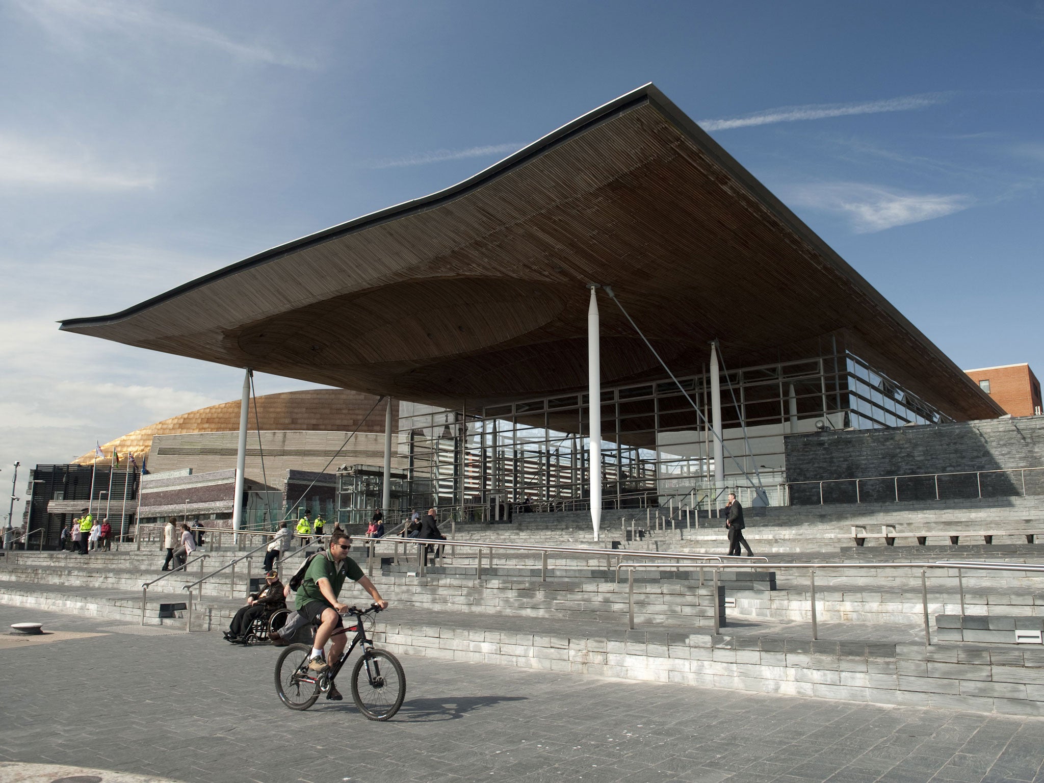 Welsh National Assembly, Cardiff:
Opened in 2006 in Cardiff docklands, a mile from city centre. Intended to signify openness and transparency of devolved Welsh government. Slate-clad plinth reaches up from shore level; lightweight undulating roof shelters