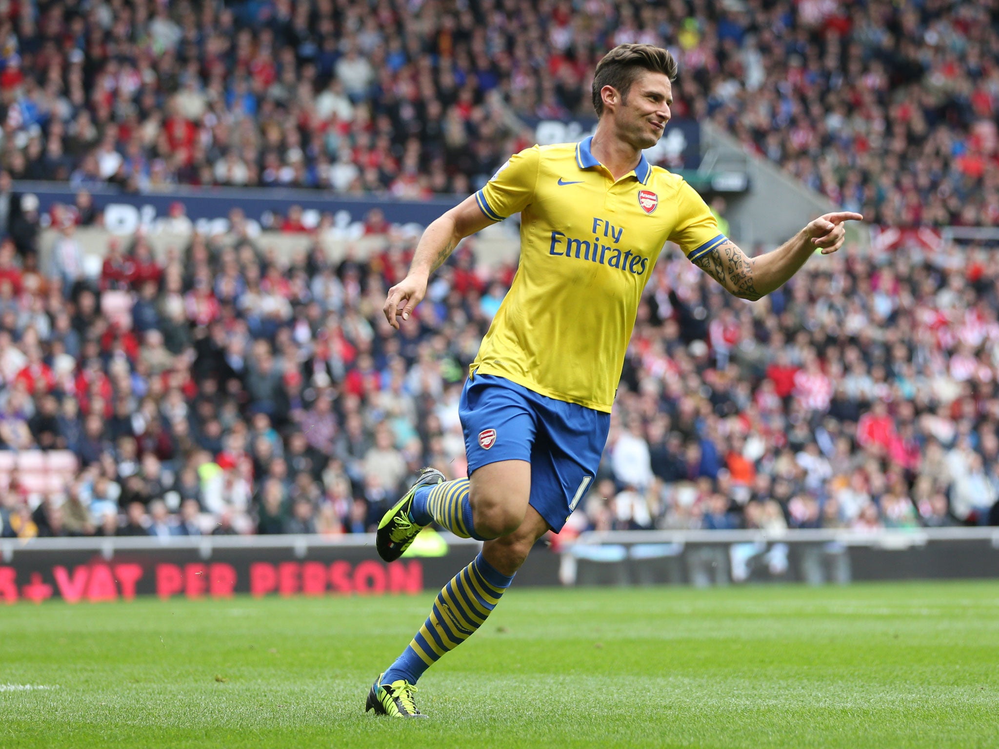 Olivier Giroud runs towards Mesut Ozil after opening the scoring for Arsenal