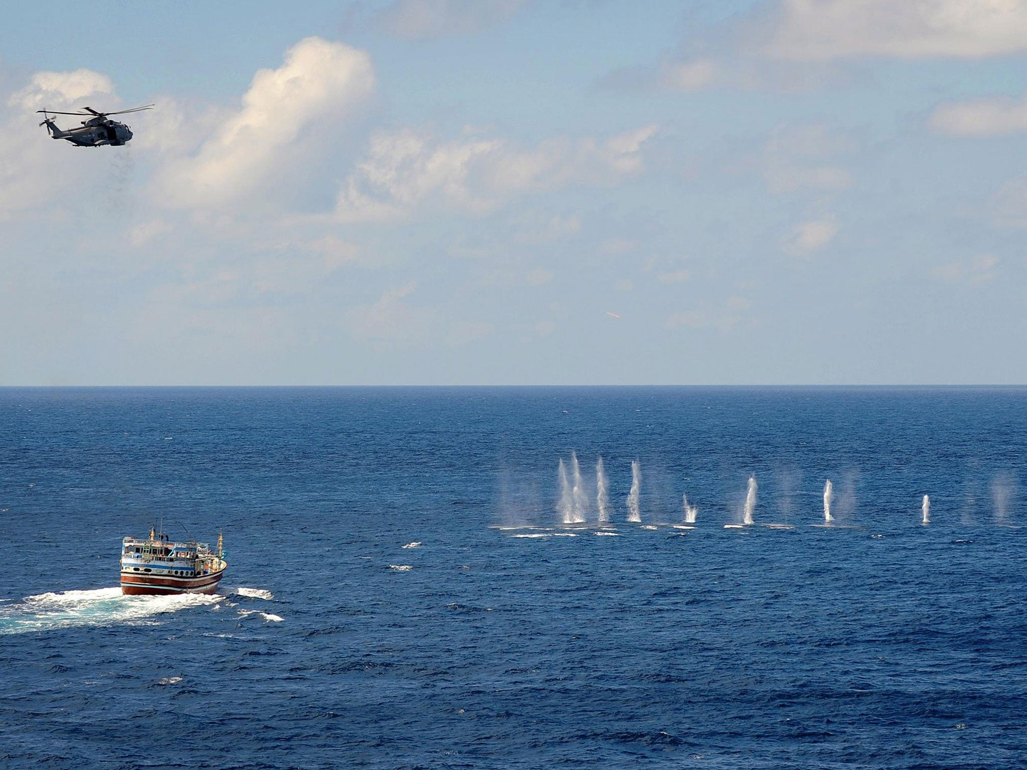 HMS Somerset's merlin helicopter putting shots across the bow of the dhow, believed to be the mother ship of the pirate group that failed to take the MV Montecristo, RFA Fort Victoria, in the Indian Ocean