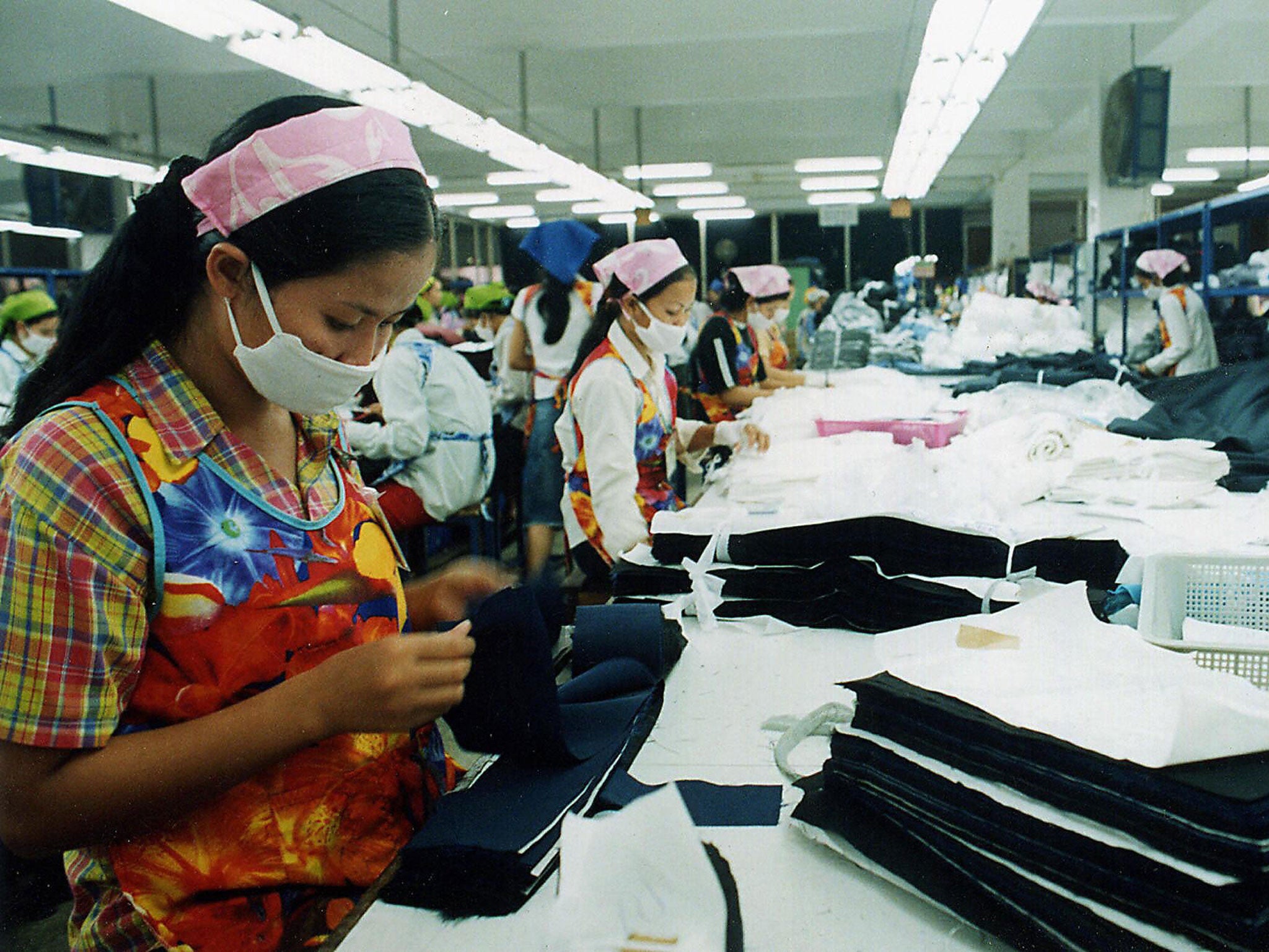 Employees of a garment factory check the quality of stitched garments before packing in the outskirts of the Cambodian capital city Phnom Penh