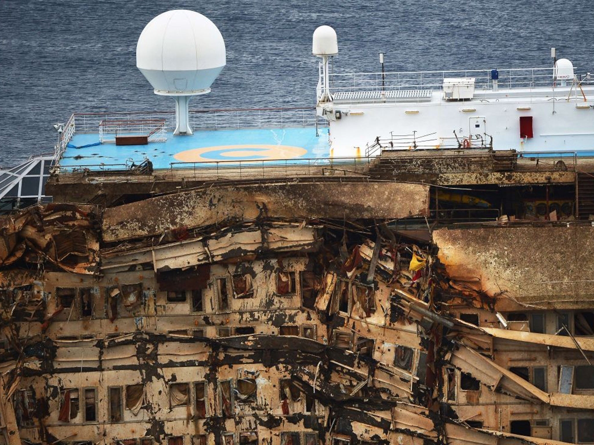 The damaged side of Costa Concordia cruise ship has emerged from the sea off the Italian island of Giglio