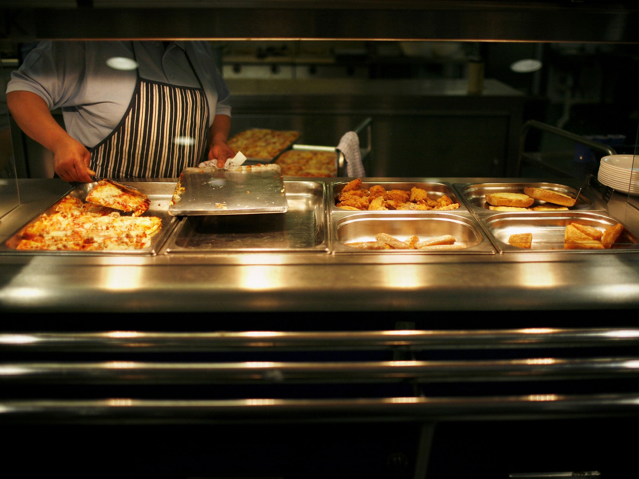 A staff member prepares a school meal in Quintin Kynaston School on December 14, 2005 in London.