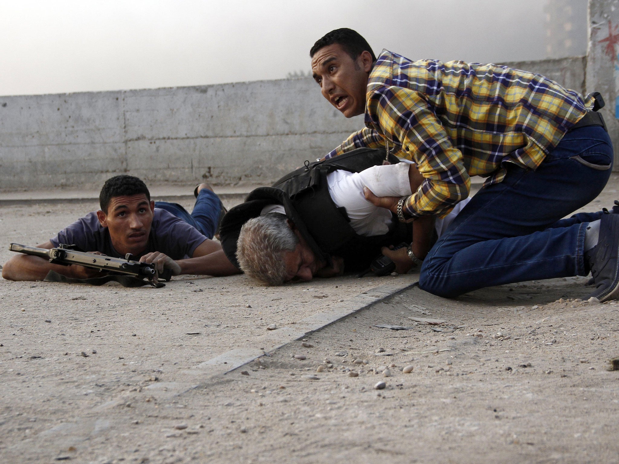 Security forces try to help Gen Nabil Farag, a police chief who was killed when militants in Kerdasa opened fire on troops yesterday morning