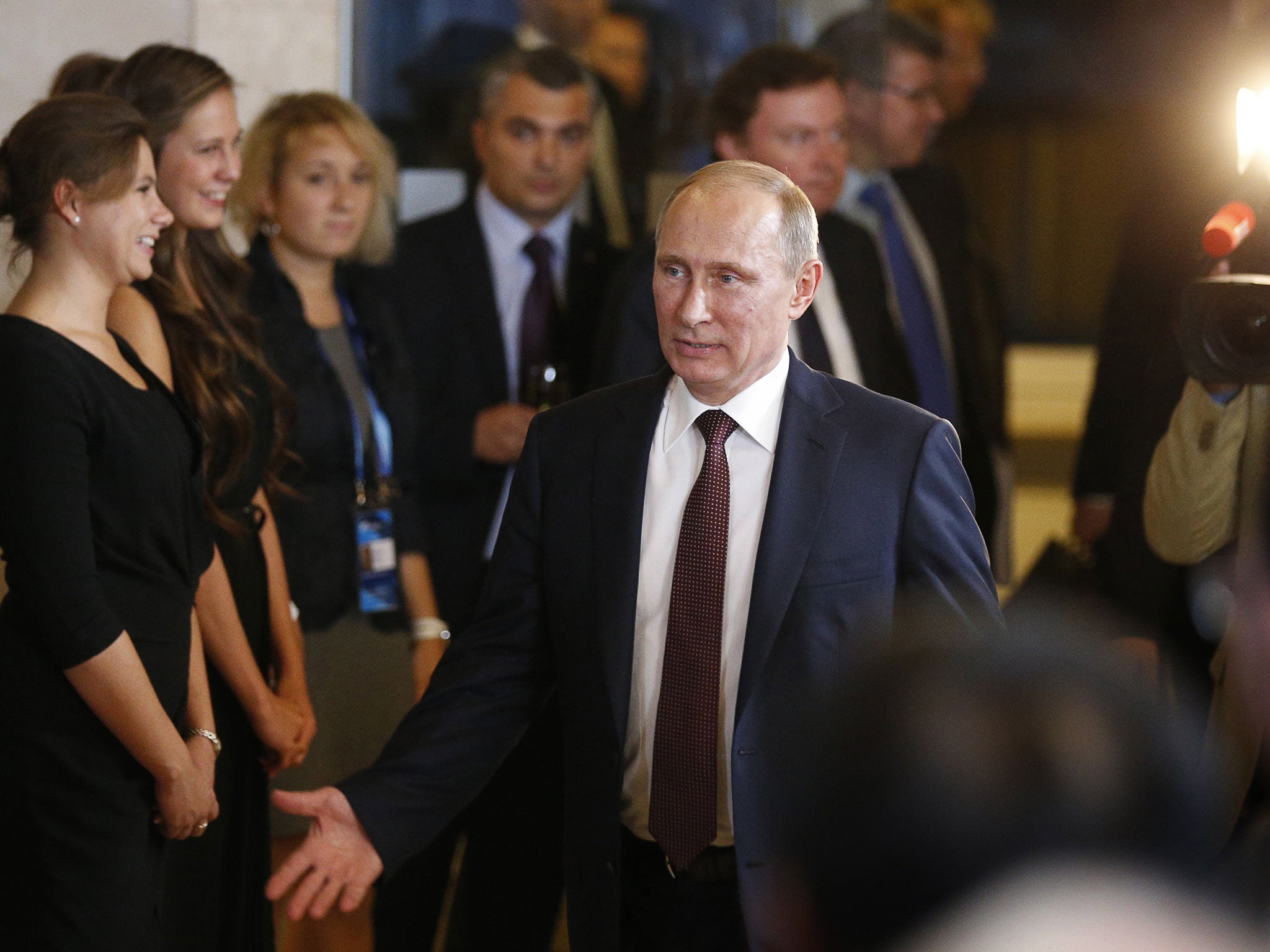 Russian President Vladimir Putin gestures as he leaves the final plenary meeting of the Valdai International Discussion Club in the Novgorod Region