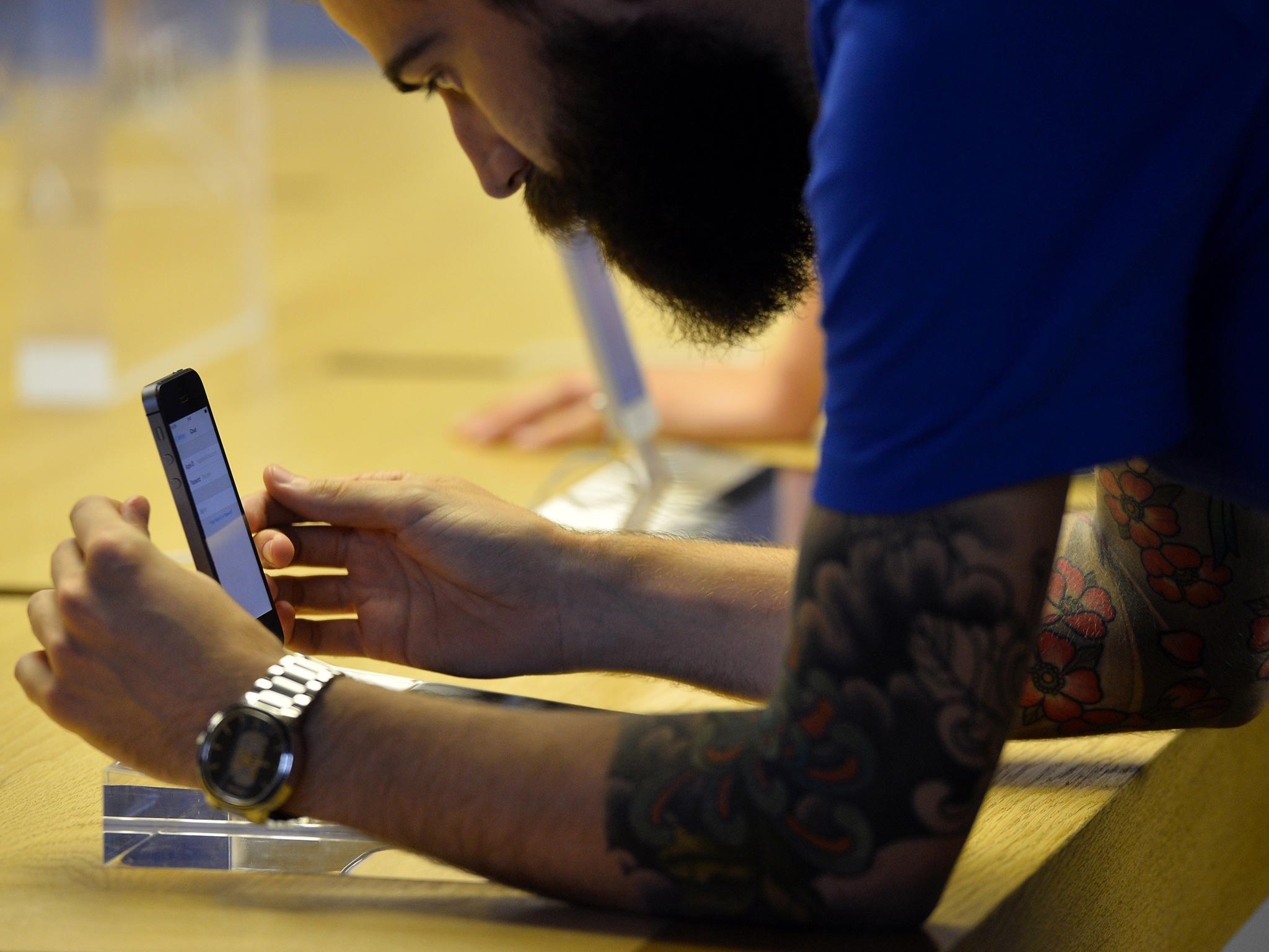 An employee prepares a display iPhone 5S's at the Apple store in preparation for opening ahead of the iPhone 5S and 5C going on sale in central London