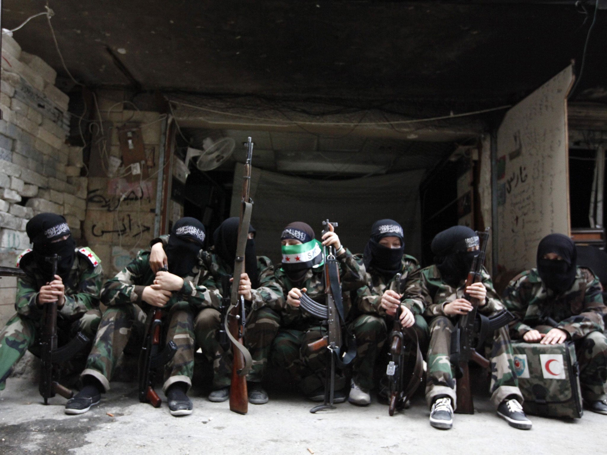 Female members of the 'Mother Aisha' battalion – an all female unit of the Syrian rebels – sit together in Aleppo’s Salaheddine district