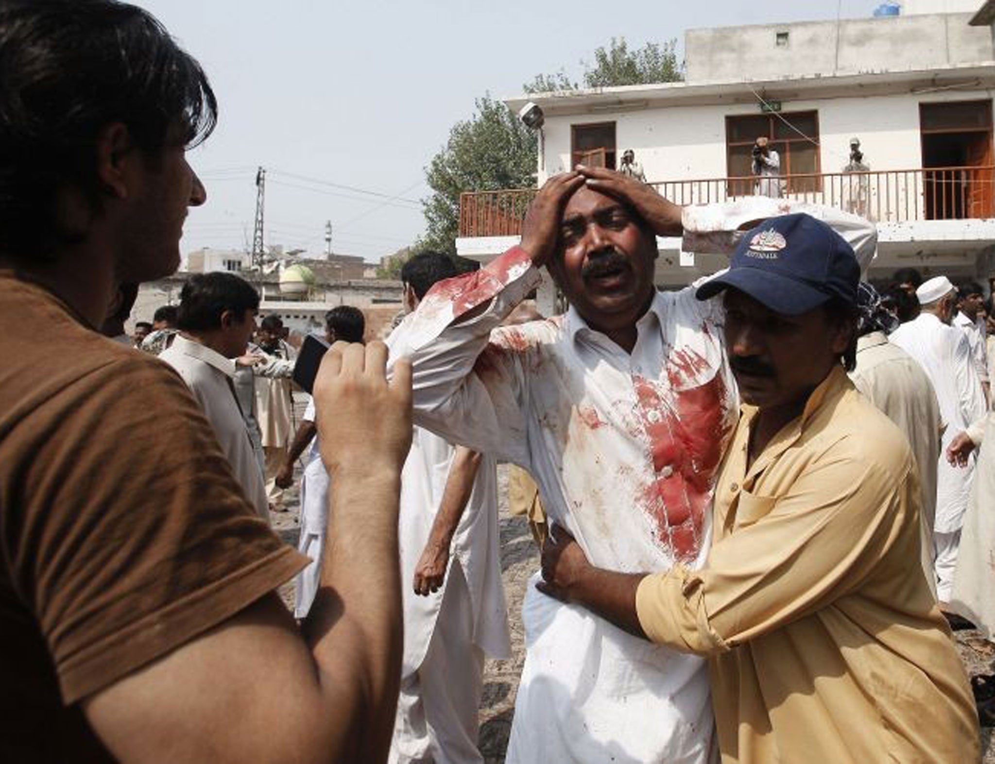 A man cries at the death of his brother at the blast site