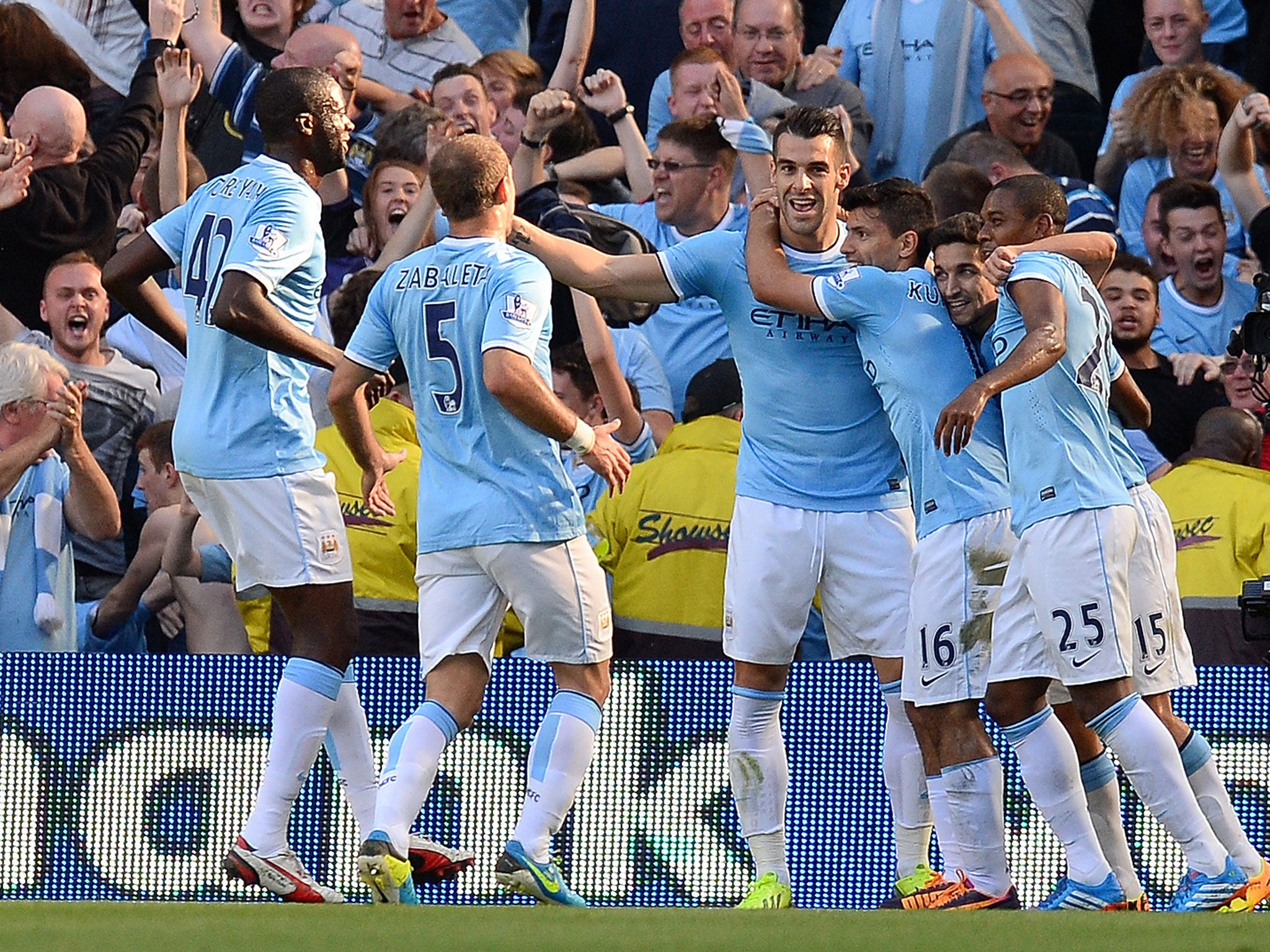 MANCHESTER, ENGLAND - SEPTEMBER 22: Manchester City's Argentinian striker Sergio Aguero celebrates with team mates after scoring the opening goal against Manchester United. GETTY IMAGES