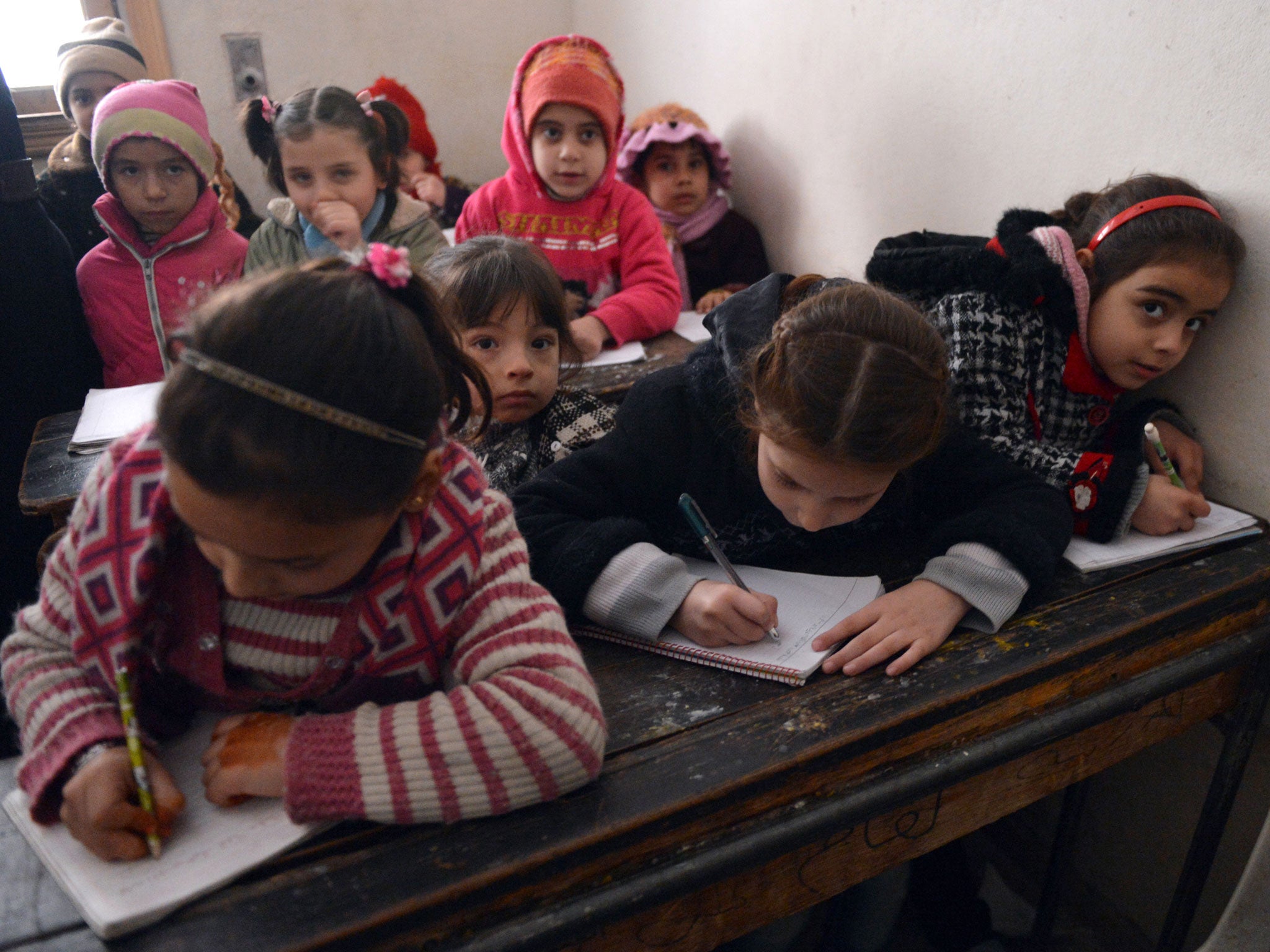 Syrian children attend a class at a school in the Kadi Askar area in the Syria's northern city of Aleppo