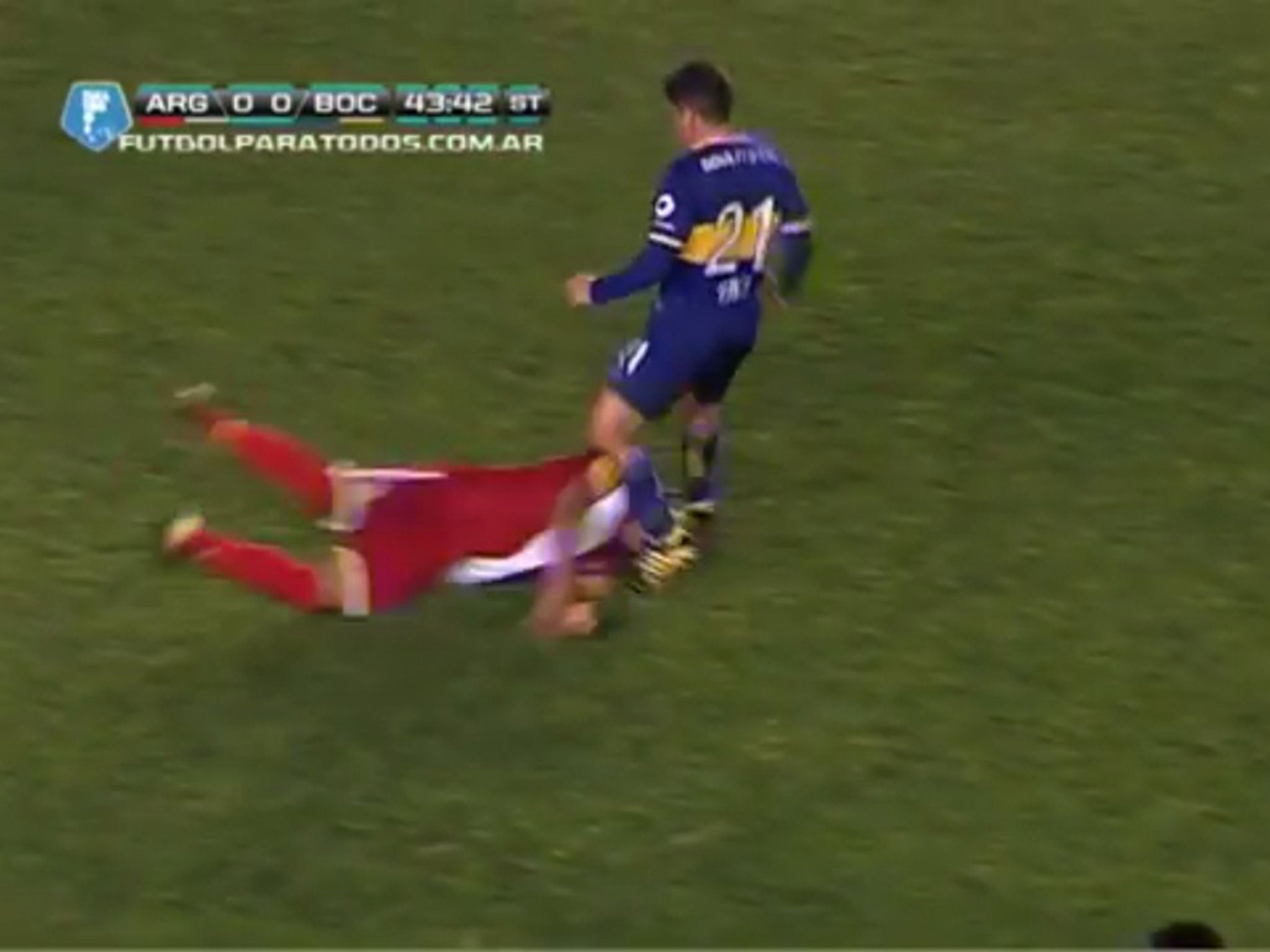 Argentinos Junior midfielder Gaspar Iniguez takes a boot to the face by Boca Juniors Christian Erbes