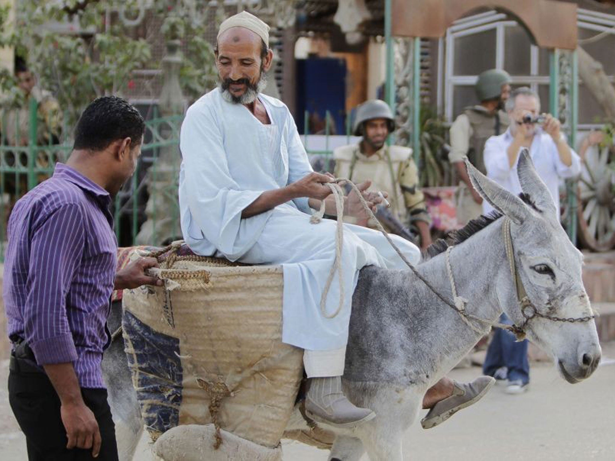 File photo: A security official searches a man riding a donkey in Kerdasa, a town 14 km (9 miles) from Cairo, on 19 September