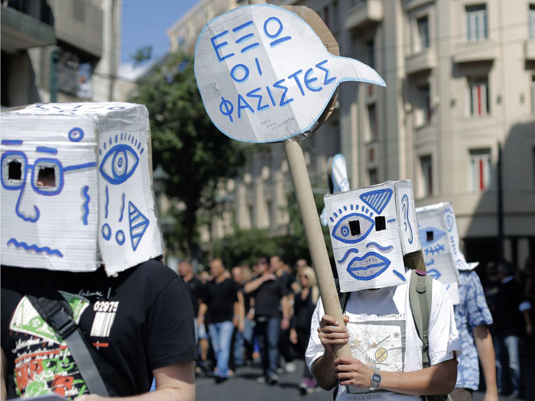 Demonstrators carry a placard which reads " Fascists Out " during a protest in central Athens