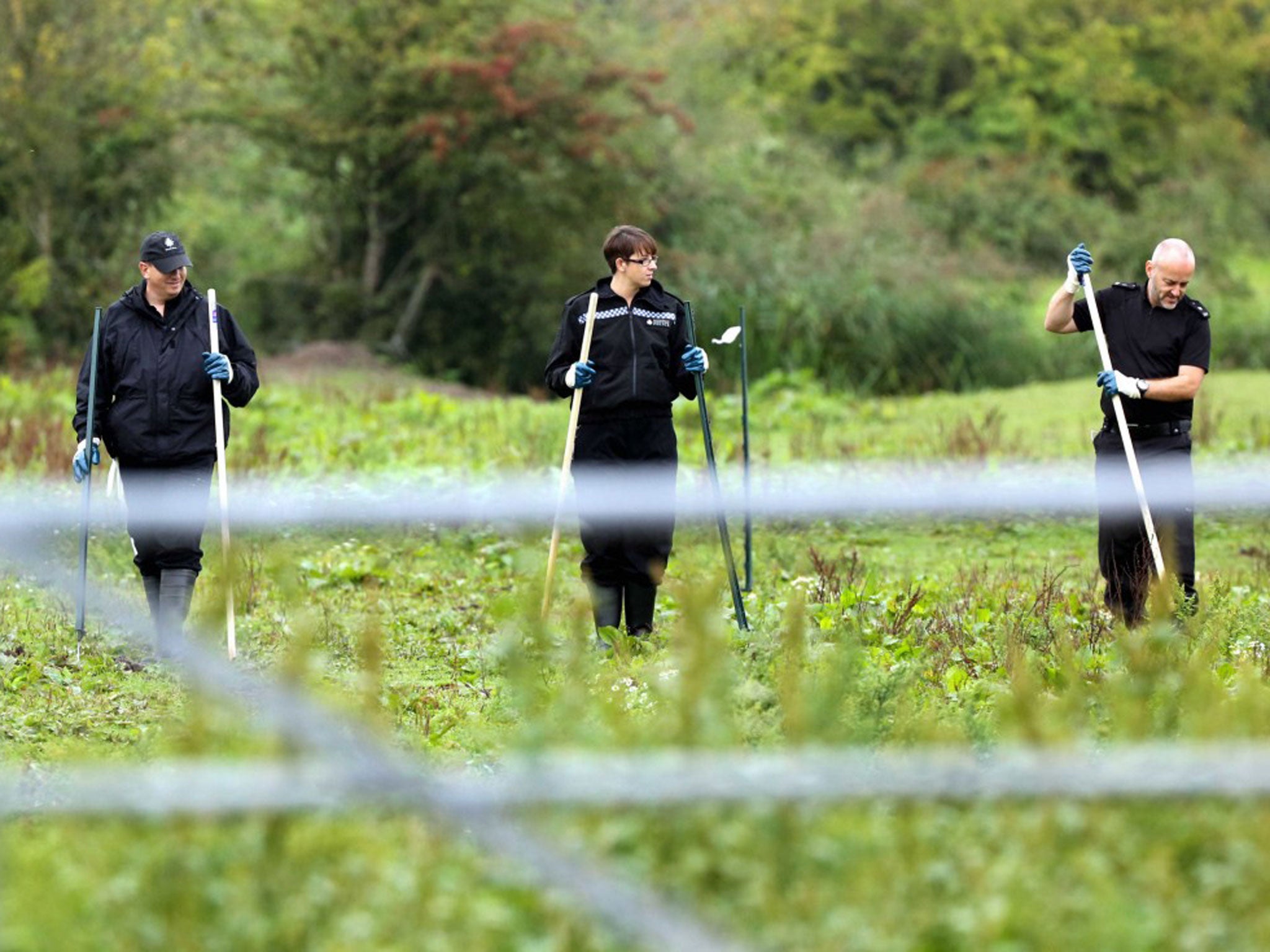 Police officers searching a field at Cariad Farm, Peterstone Wentloog, Gwent