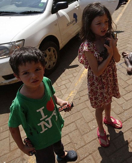 Elliot, seen wearing a green “I love New York” T-shirt, was photographed looking scared and holding a Mars bar in each hand, while a traumatised Amelie was pictured wearing a floral dress as a dead body lay at her feet