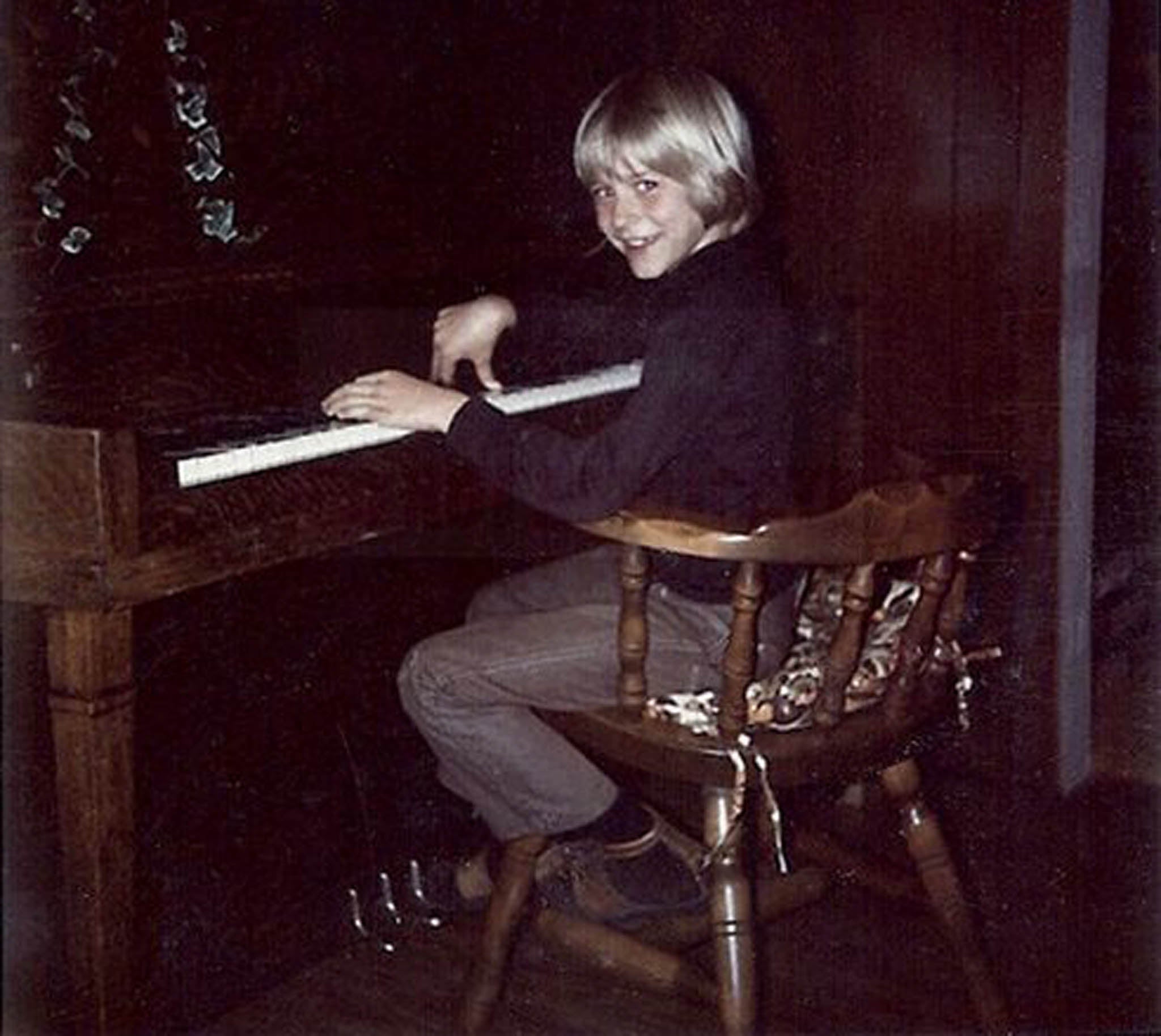 A young Kurt Cobain plays the piano in his childhood home