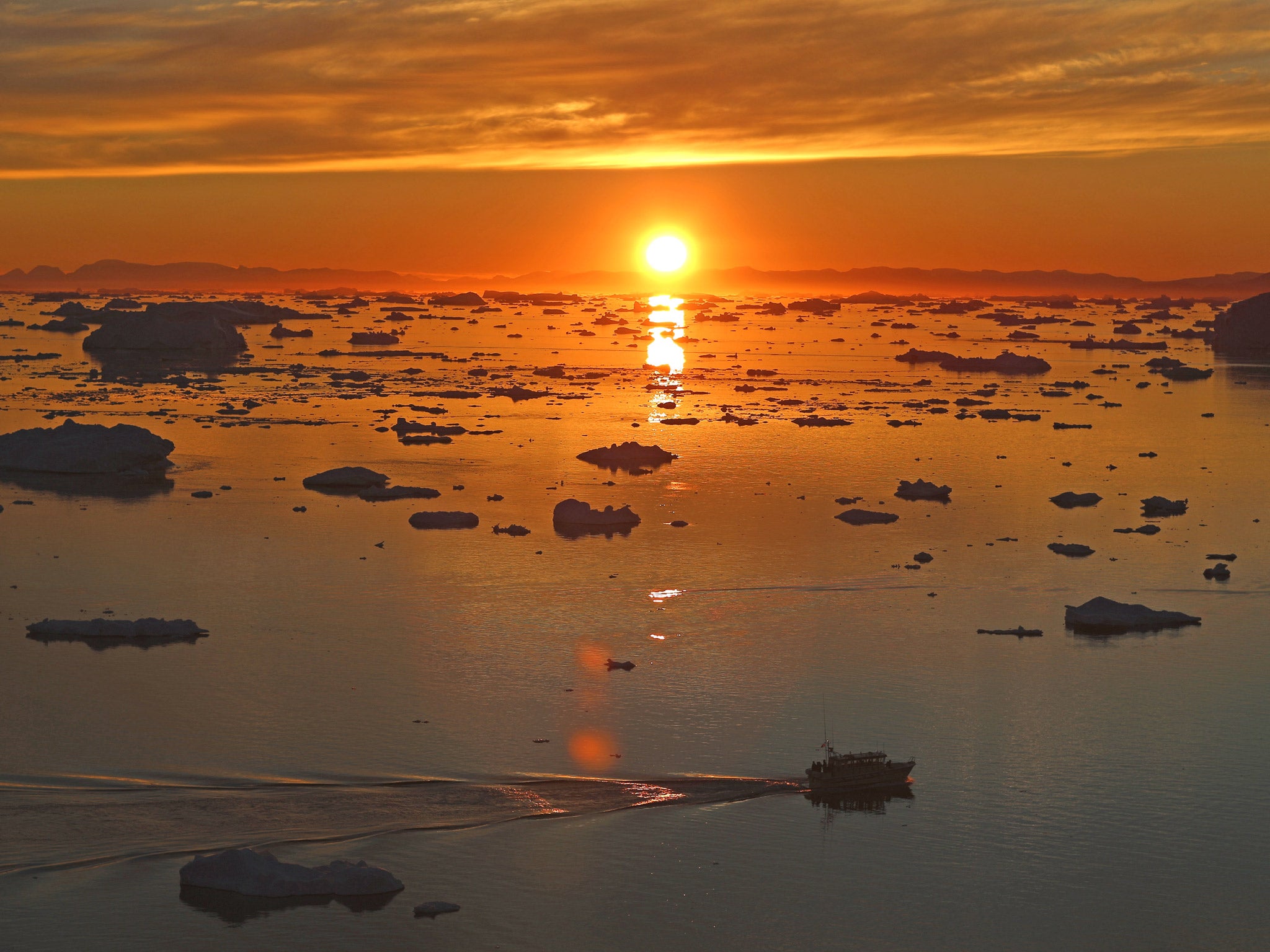 A boat is seen seen among the icebergs that broke off from the Jakobshavn Glacier in Ilulissat, Greenland