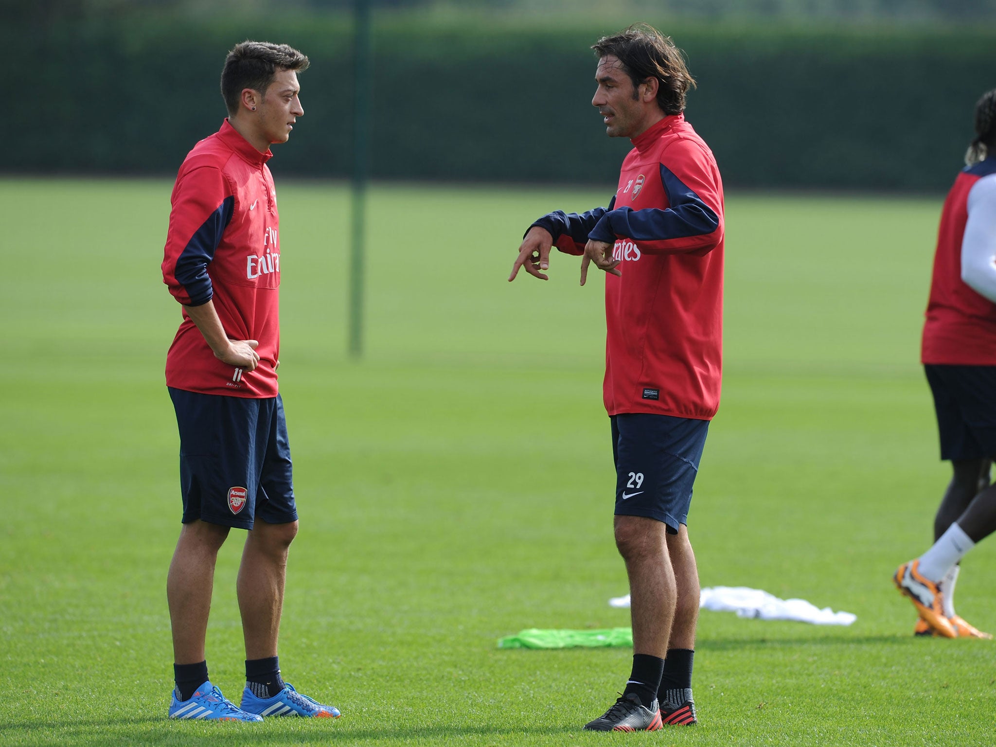 Ozil listens as Pires gives the Arsenal man some advice