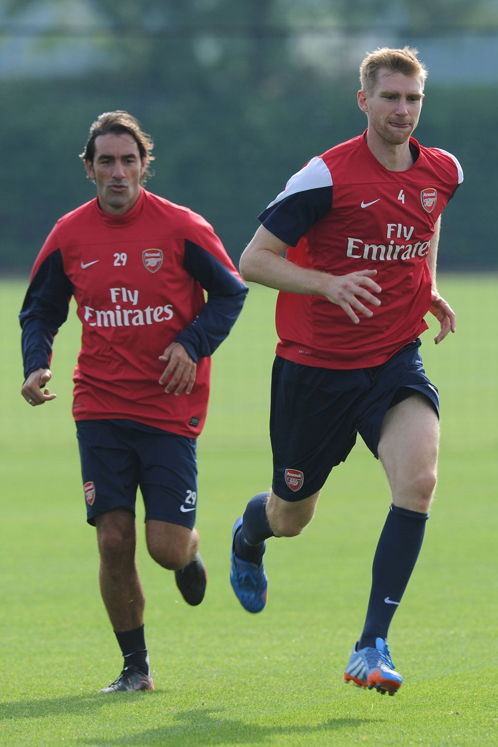 Pires and Mertesacker race each other during Arsenal training