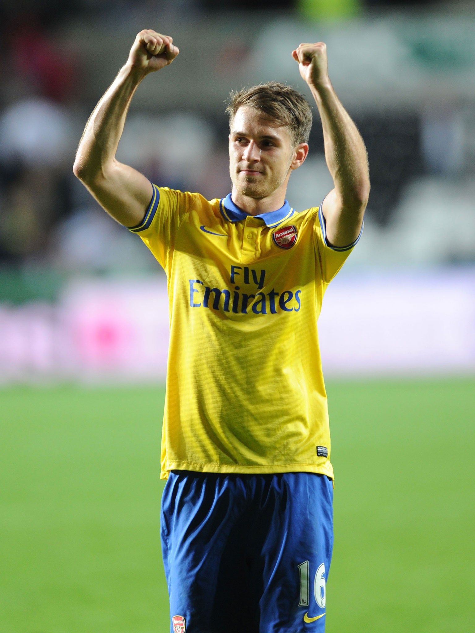 Aaron Ramsey raises his arms in triumph at the final whistle