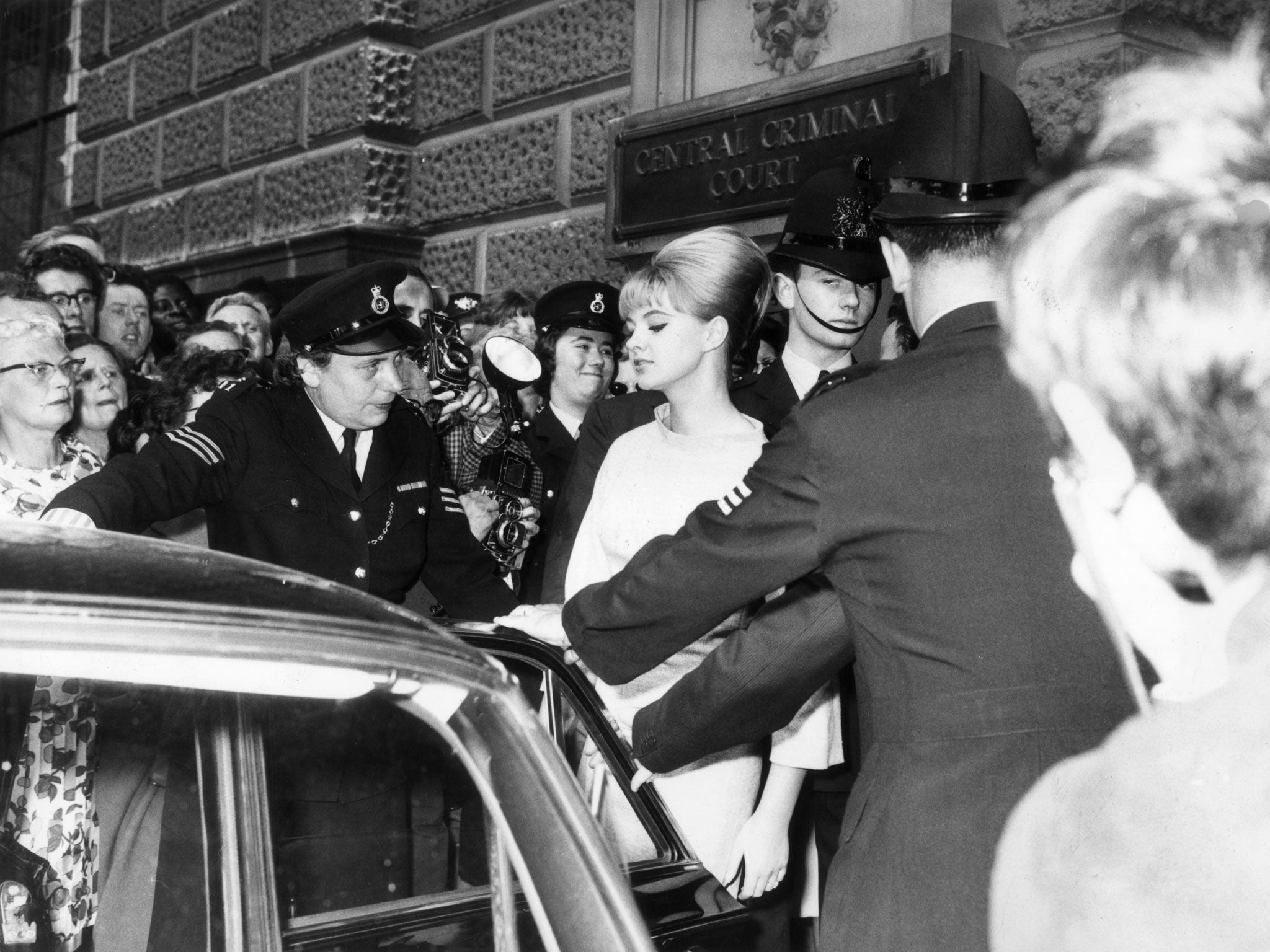 Mandy Rice-Davies involved in the Profumo affair being escorted to a car by the police during the trial of Dr Stephen Ward