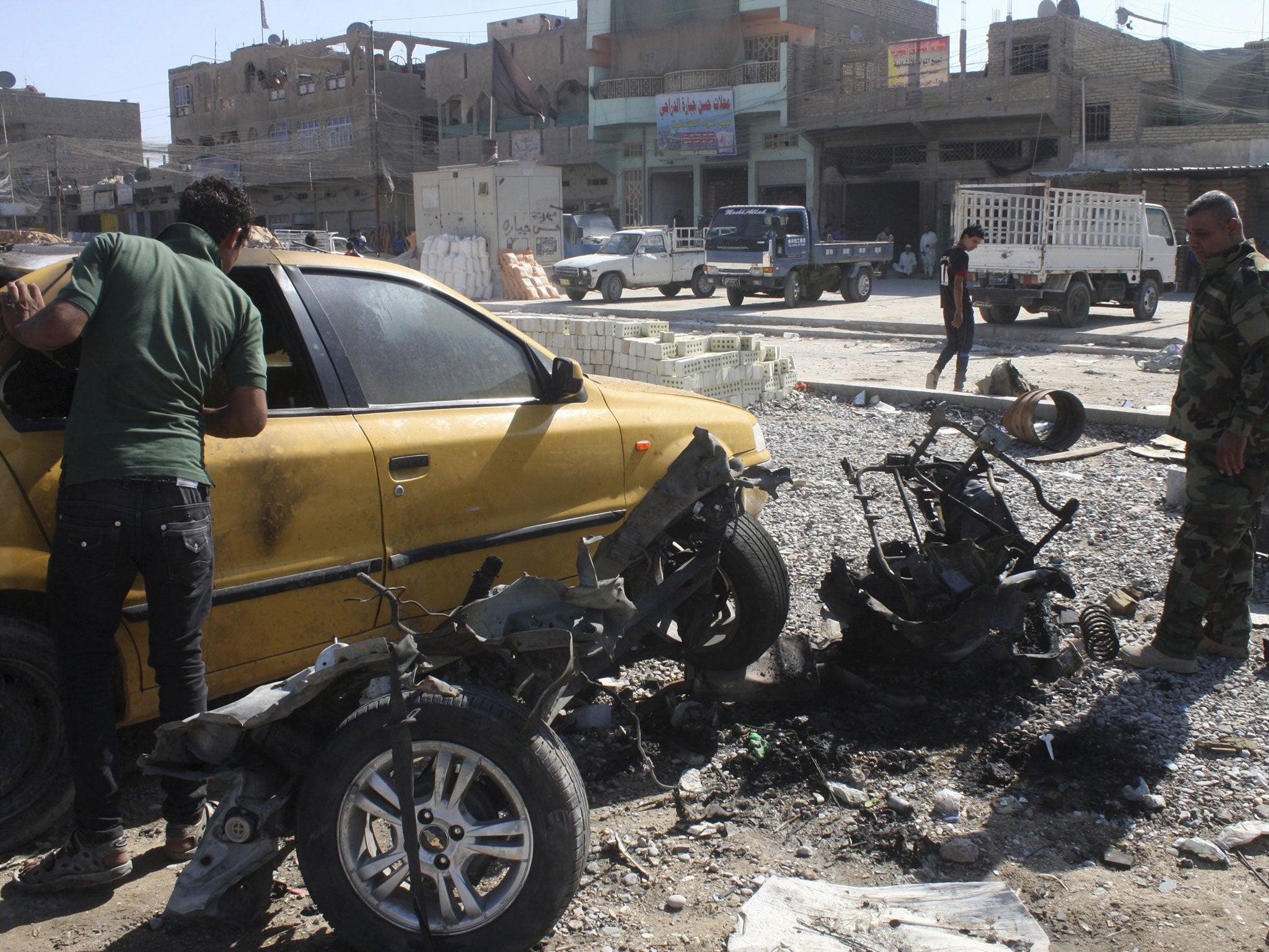 A policeman examines a vehicle used as a car bomb in Baghdad's Sadr City